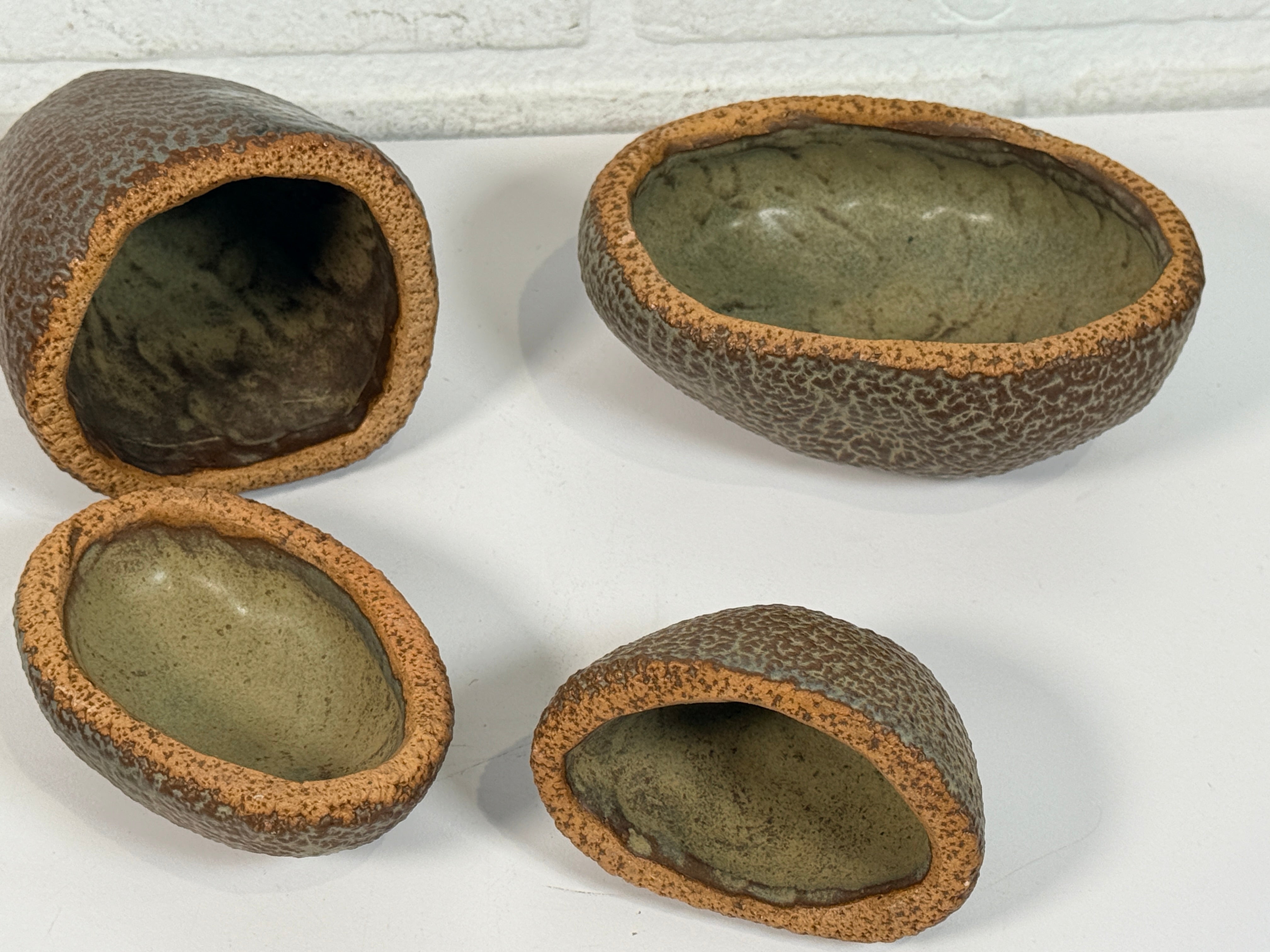 Vintage sculptural nesting pebble vessels set of 4 studio pottery ceramic organic modern brutalist decor art objects collectible display pieces.