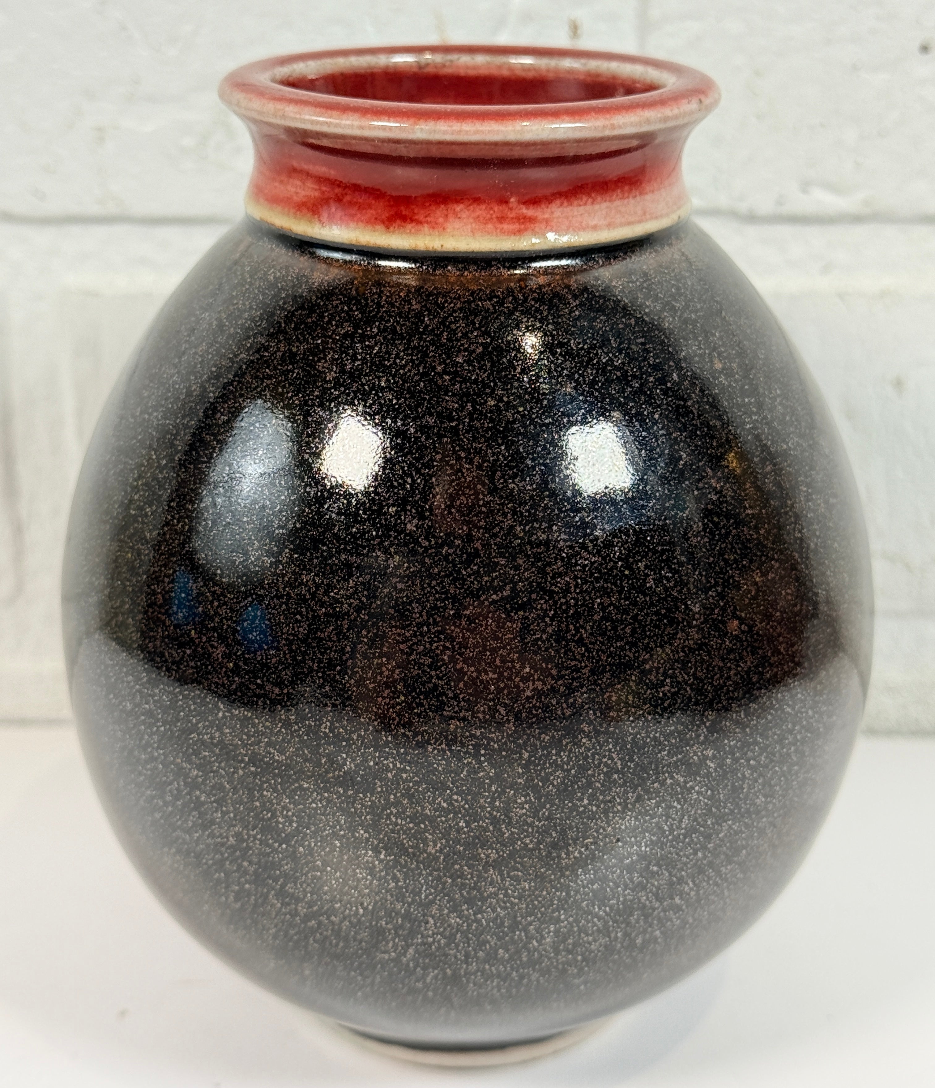 Elizabeth Wolcott signed Canadian studio pottery vase with black glaze and oxblood rim. Handmade ceramic art vase collectible decor piece.
