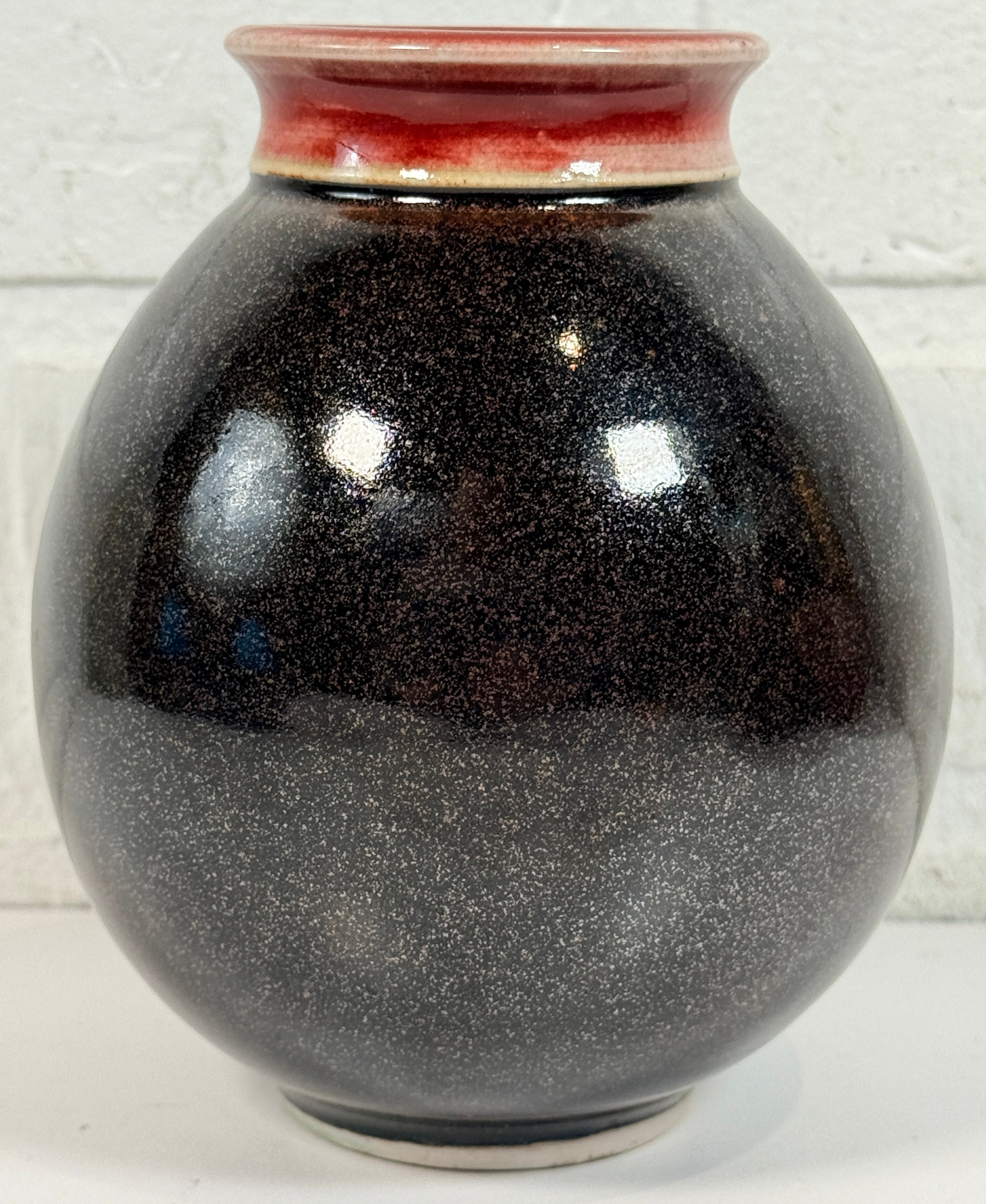 Elizabeth Wolcott signed Canadian studio pottery vase with black glaze and oxblood rim. Handmade ceramic art vase collectible decor piece.
