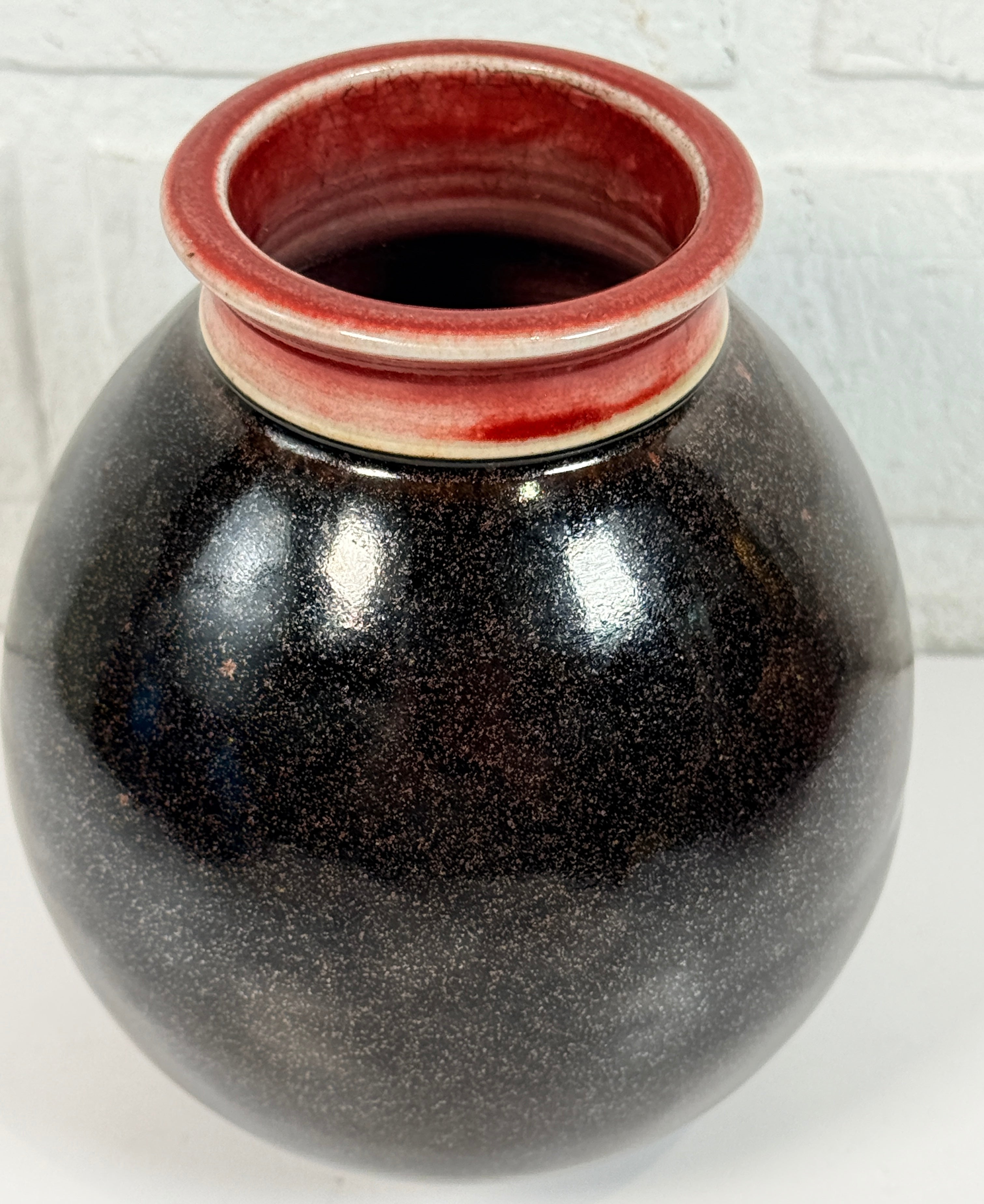 Elizabeth Wolcott signed Canadian studio pottery vase with black glaze and oxblood rim. Handmade ceramic art vase collectible decor piece.