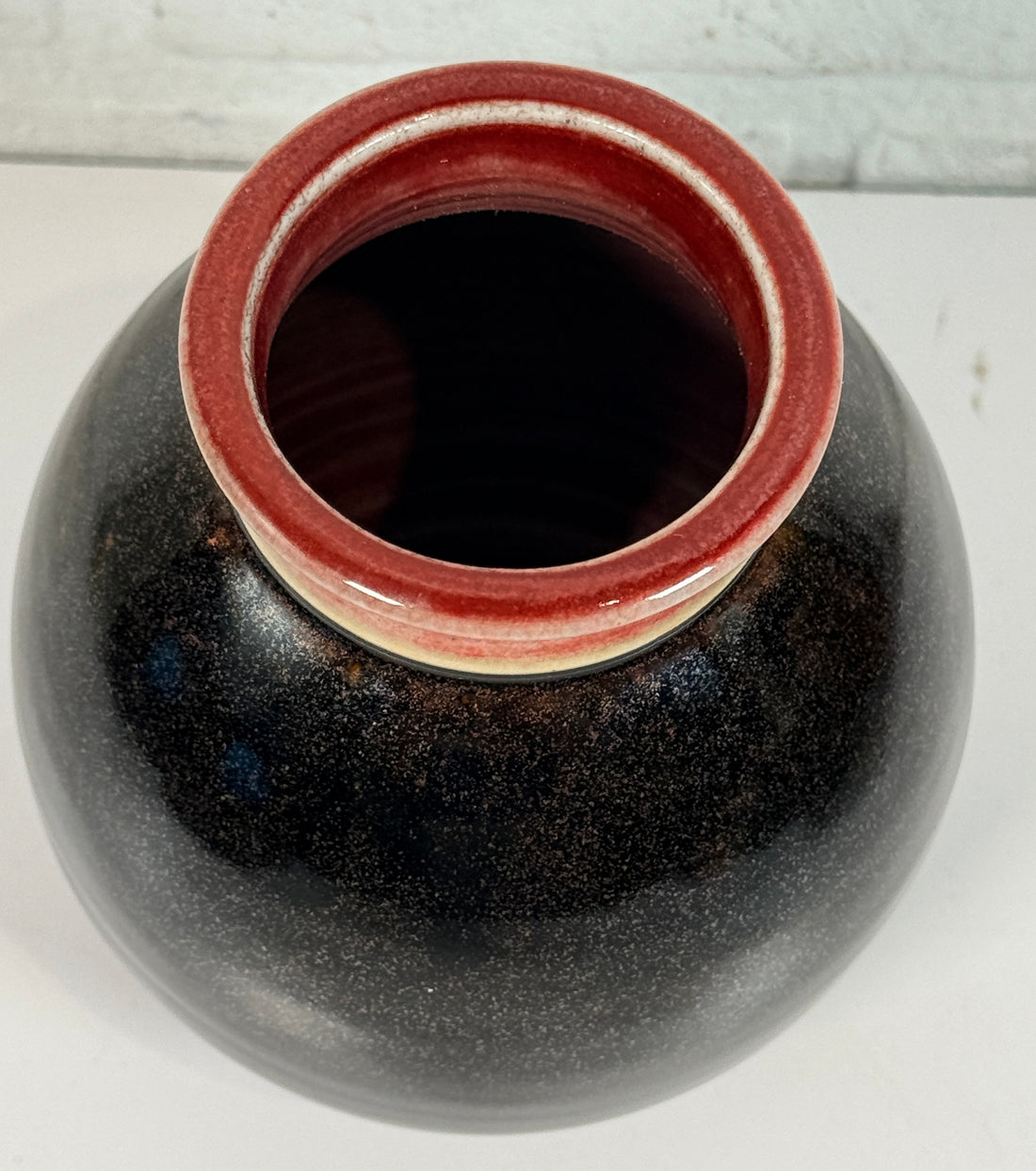 Elizabeth Wolcott signed Canadian studio pottery vase with black glaze and oxblood rim. Handmade ceramic art vase collectible decor piece.