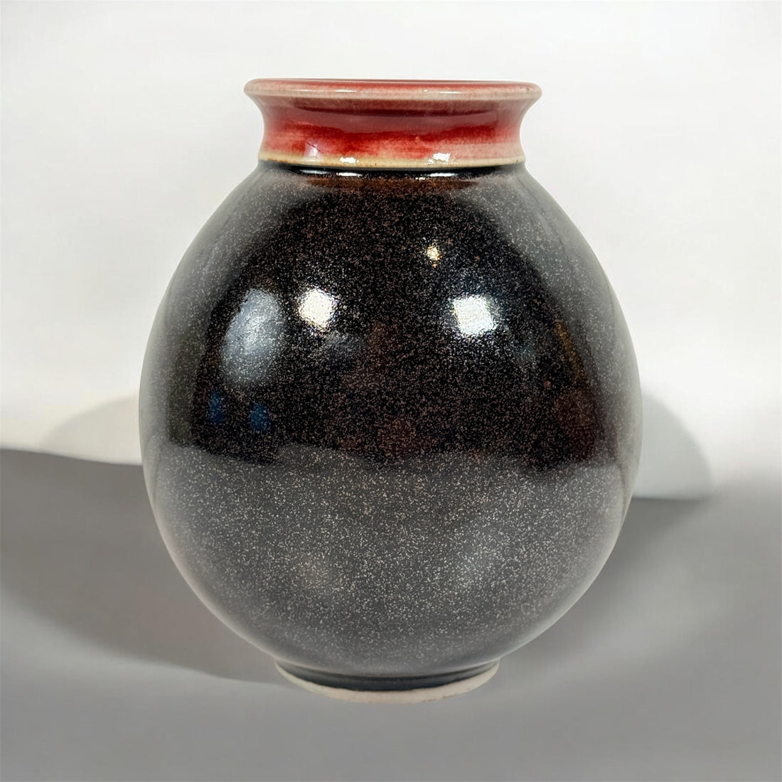 Elizabeth Wolcott signed Canadian studio pottery vase with black glaze and oxblood rim. Handmade ceramic art vase collectible decor piece.