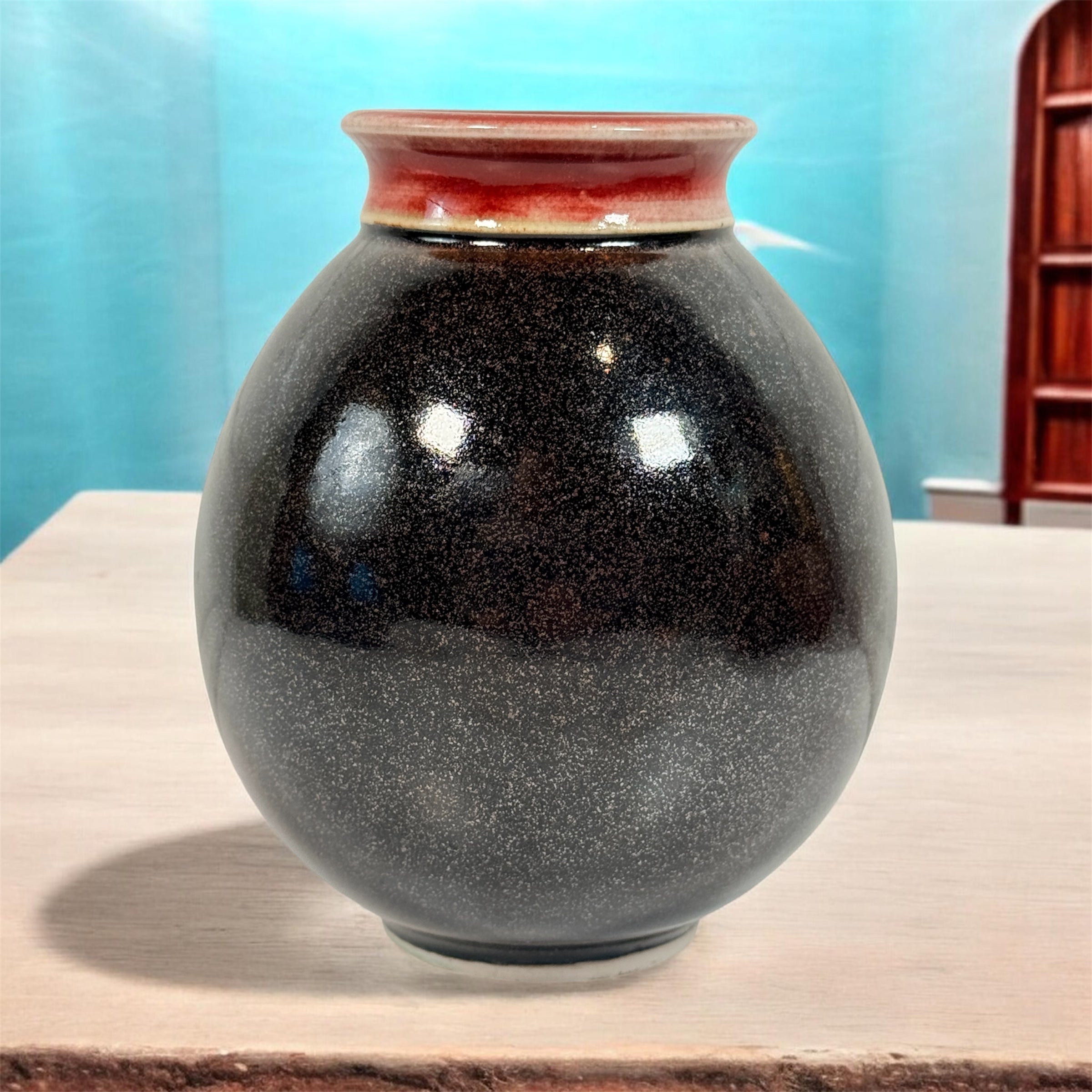 Elizabeth Wolcott signed Canadian studio pottery vase with black glaze and oxblood rim. Handmade ceramic art vase collectible decor piece.