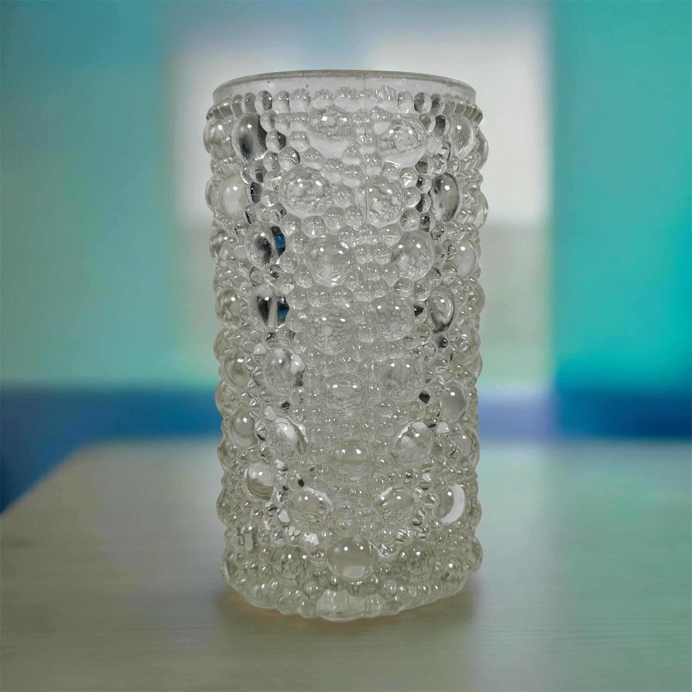 Mid-century modern clear bubble glass cylinder vase with Scandinavian style. Heavy textured art glass décor piece from the 1960s–70s.