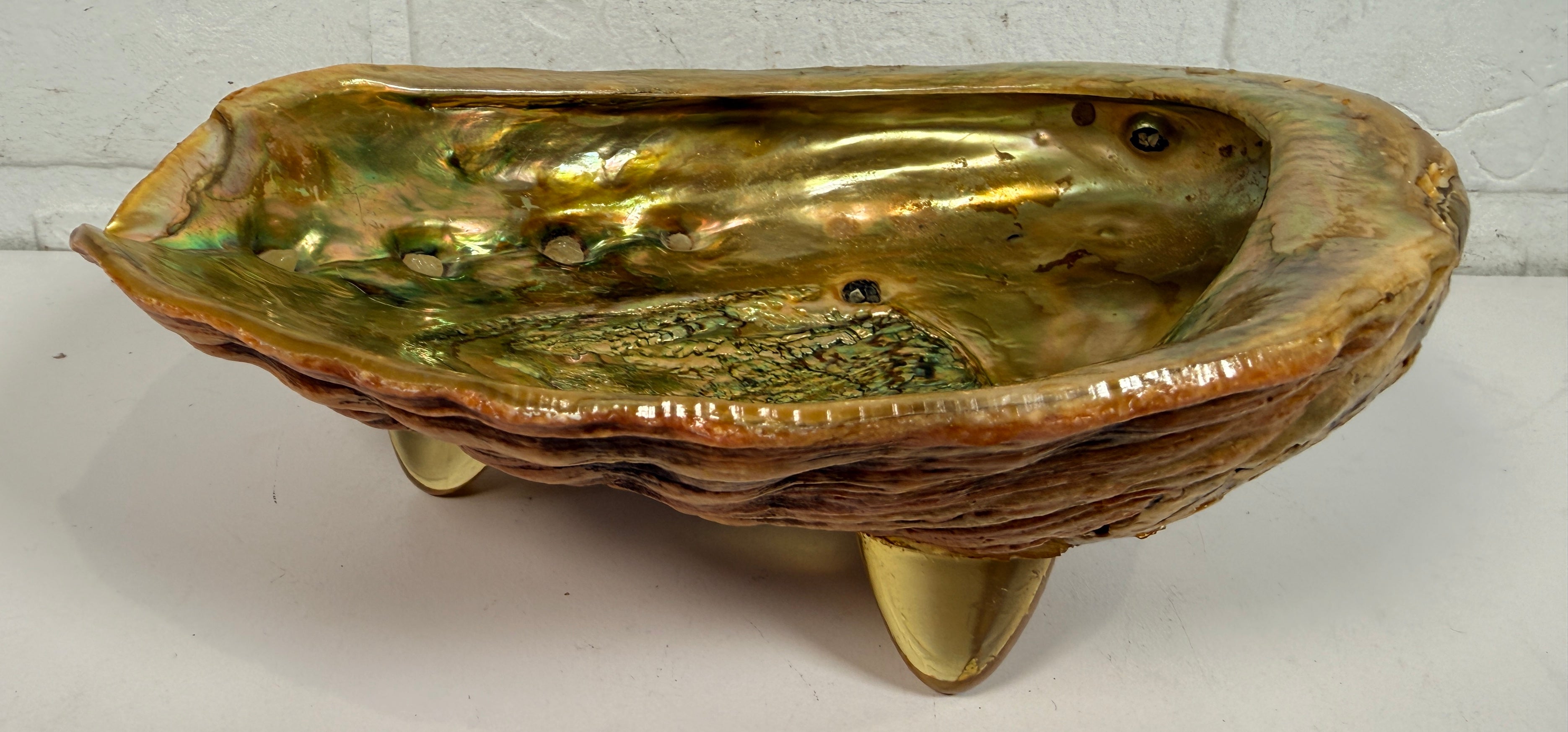 Vintage abalone shell bowl with lucite feet. Iridescent centerpiece dish for coastal, tiki, Hollywood Regency, and mid-century modern decor.