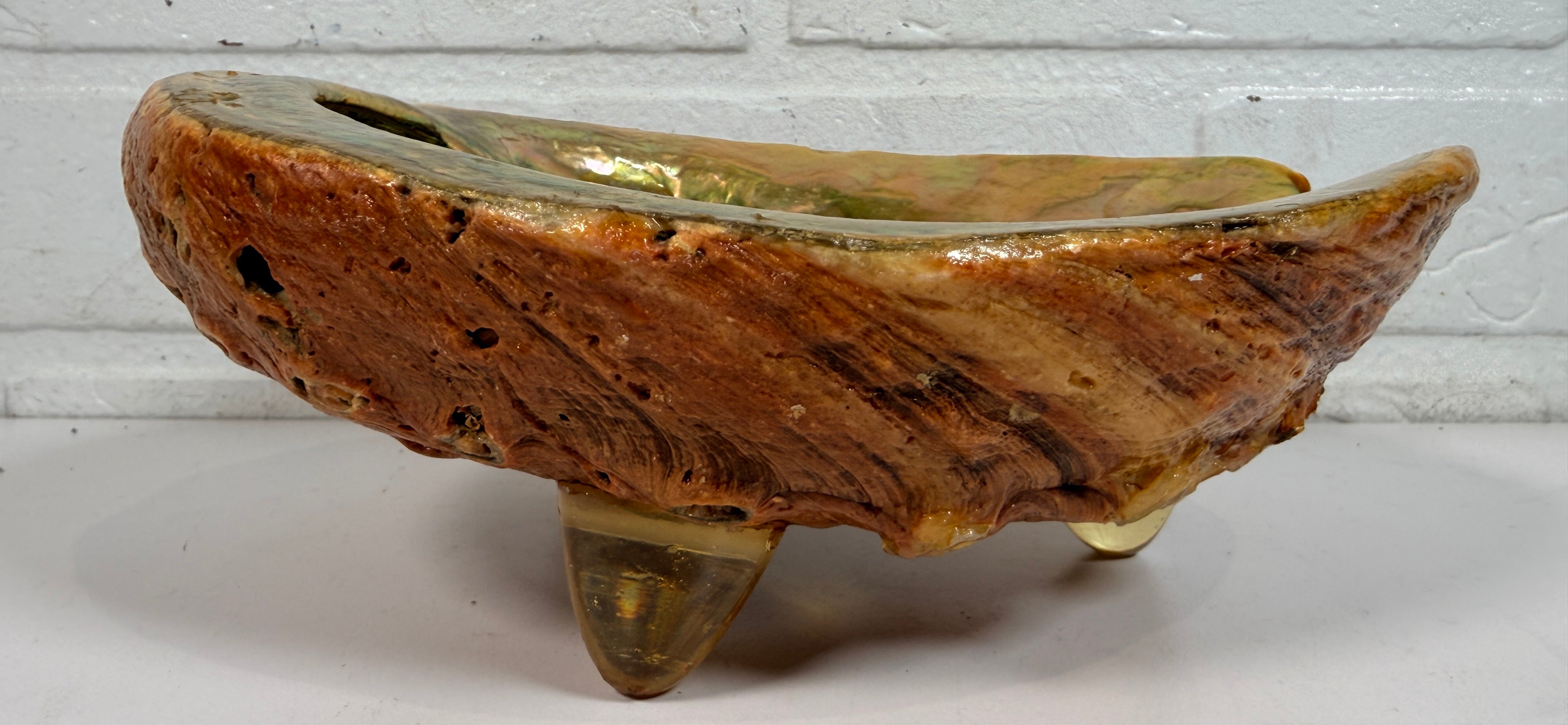 Vintage abalone shell bowl with lucite feet. Iridescent centerpiece dish for coastal, tiki, Hollywood Regency, and mid-century modern decor.