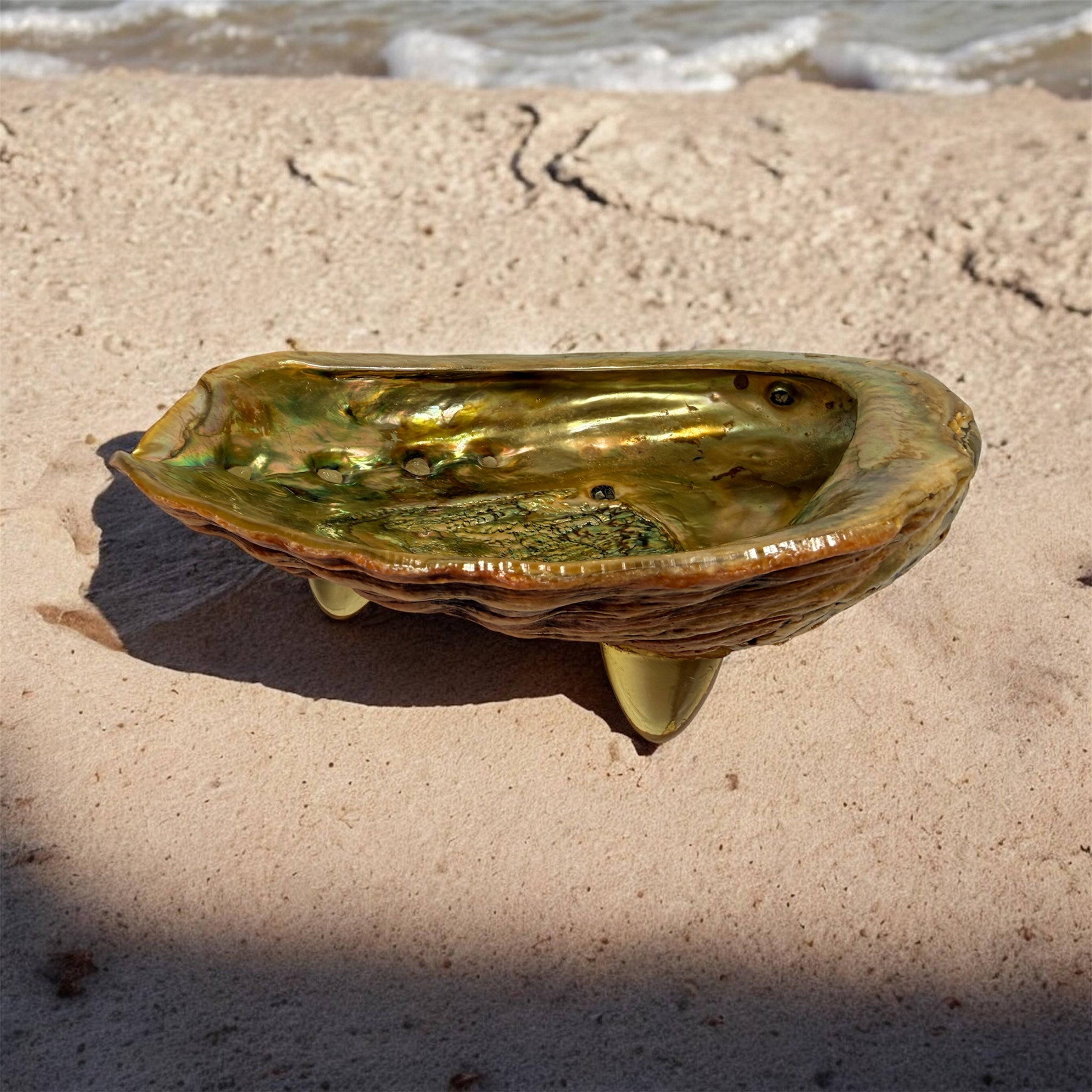 Vintage abalone shell bowl with lucite feet. Iridescent centerpiece dish for coastal, tiki, Hollywood Regency, and mid-century modern decor.