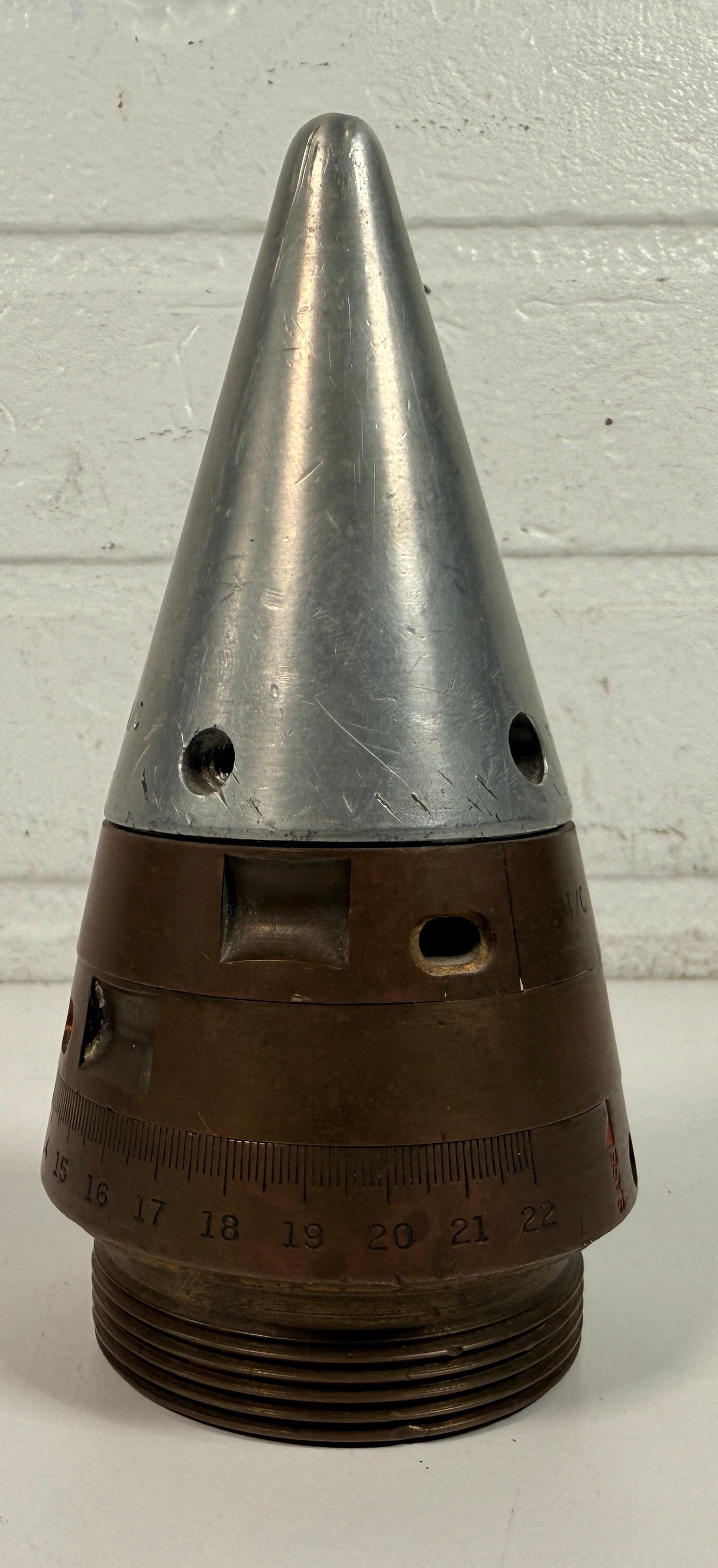 WWII British mechanical time fuze Mk IV brass and aluminum artillery nose assembly. Authentic militaria collectible with timer dial and industrial display appeal.
