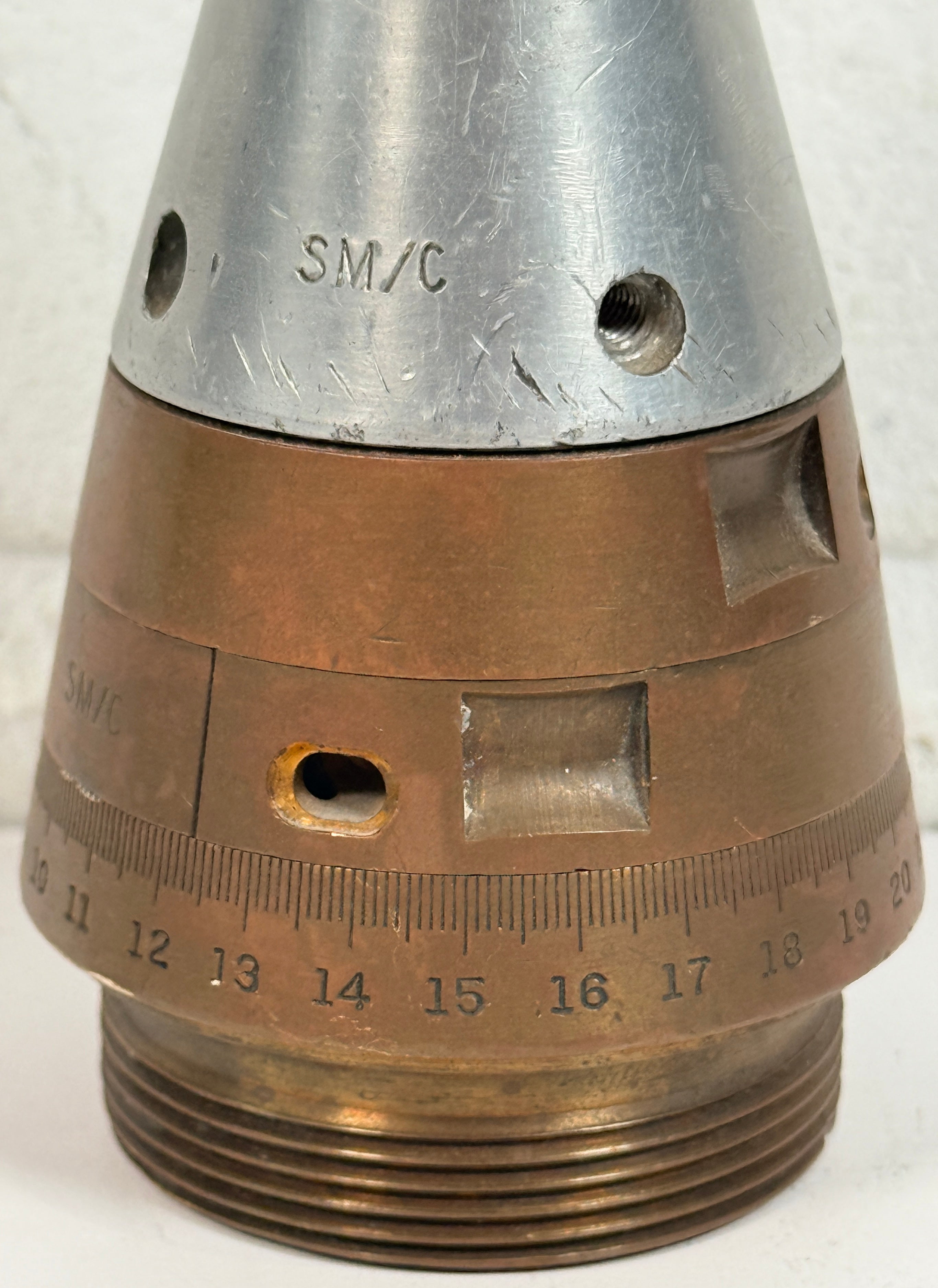 WWII British mechanical time fuze Mk IV brass and aluminum artillery nose assembly. Authentic militaria collectible with timer dial and industrial display appeal.
