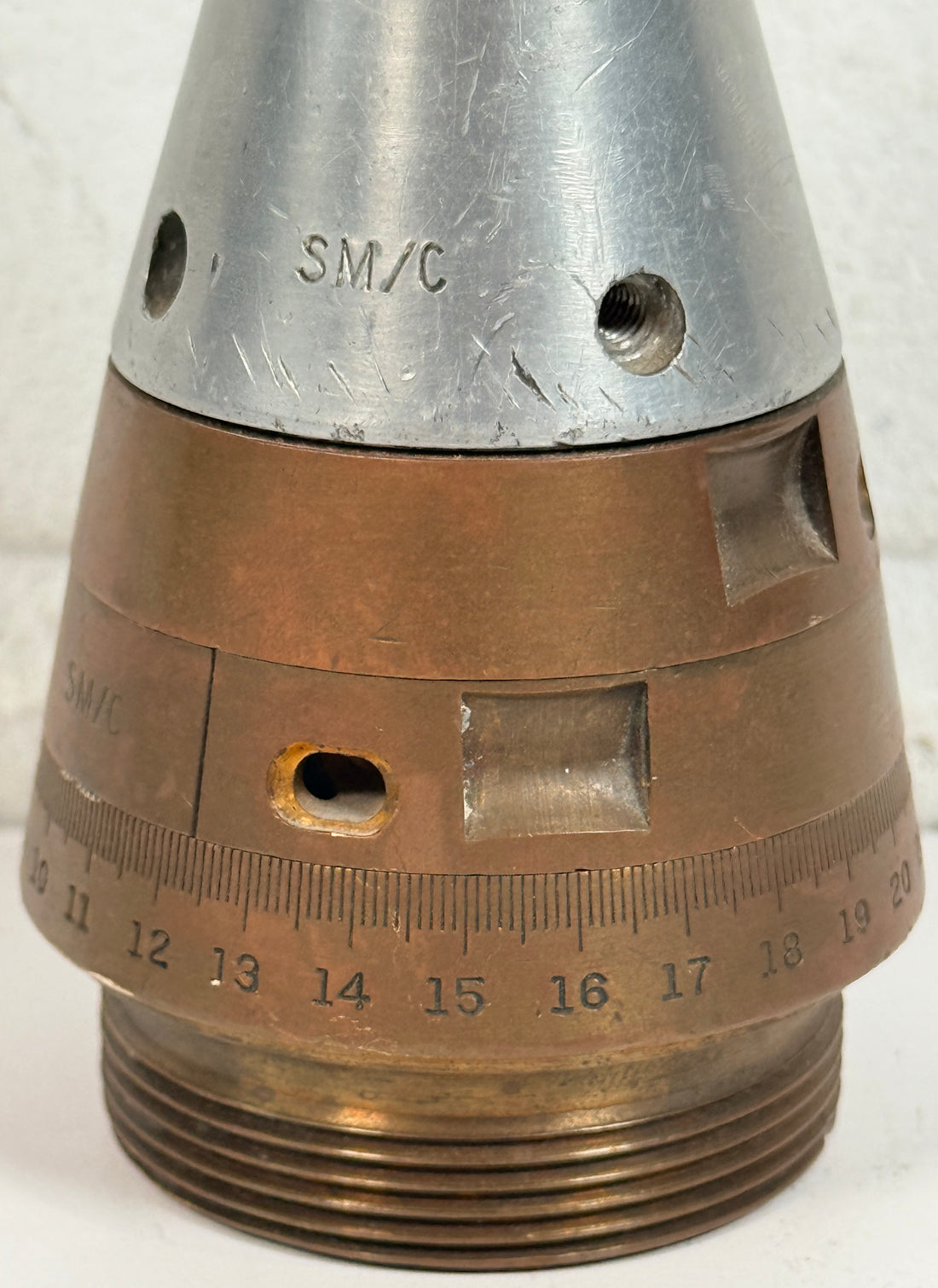 WWII British mechanical time fuze Mk IV brass and aluminum artillery nose assembly. Authentic militaria collectible with timer dial and industrial display appeal.