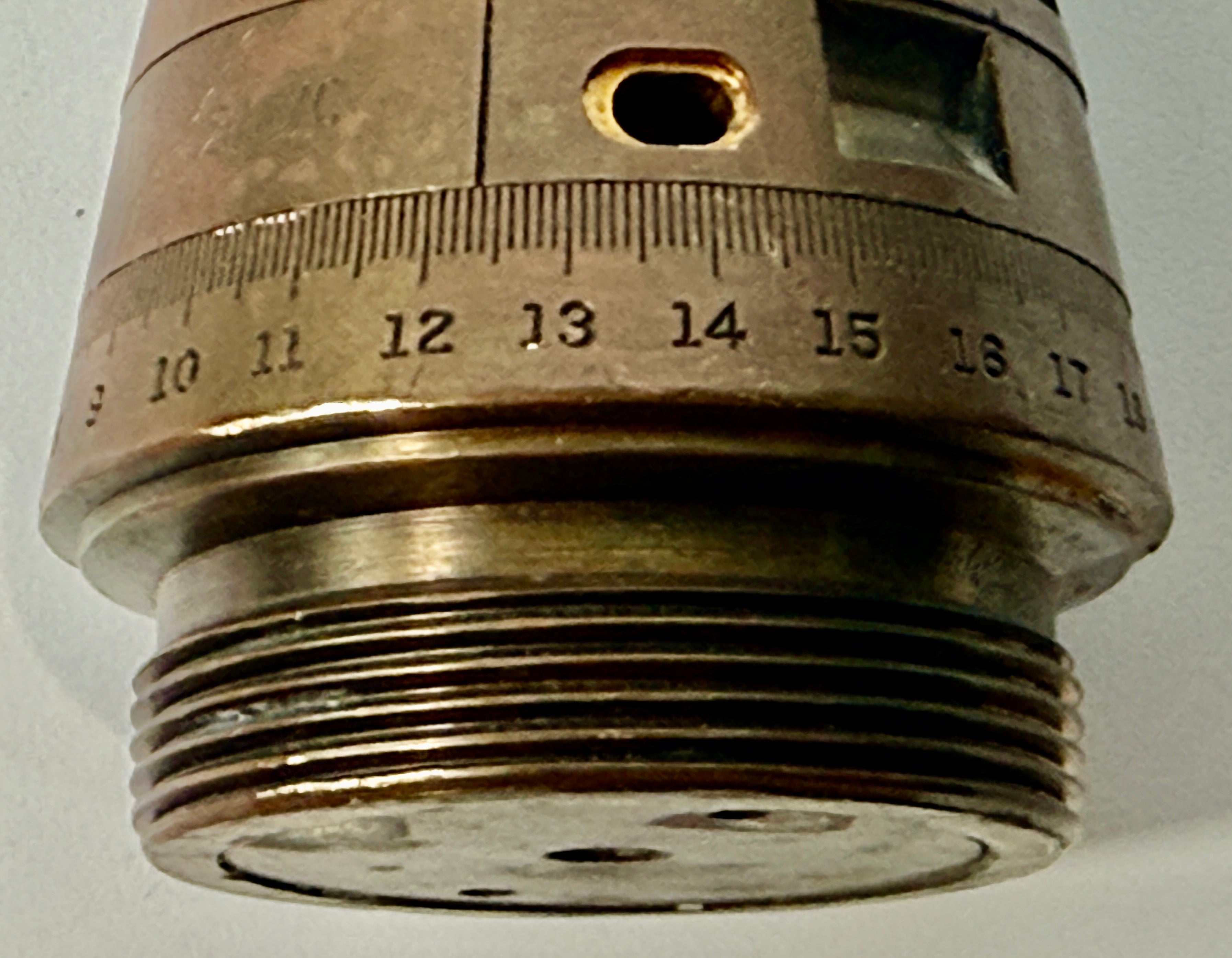 WWII British mechanical time fuze Mk IV brass and aluminum artillery nose assembly. Authentic militaria collectible with timer dial and industrial display appeal.