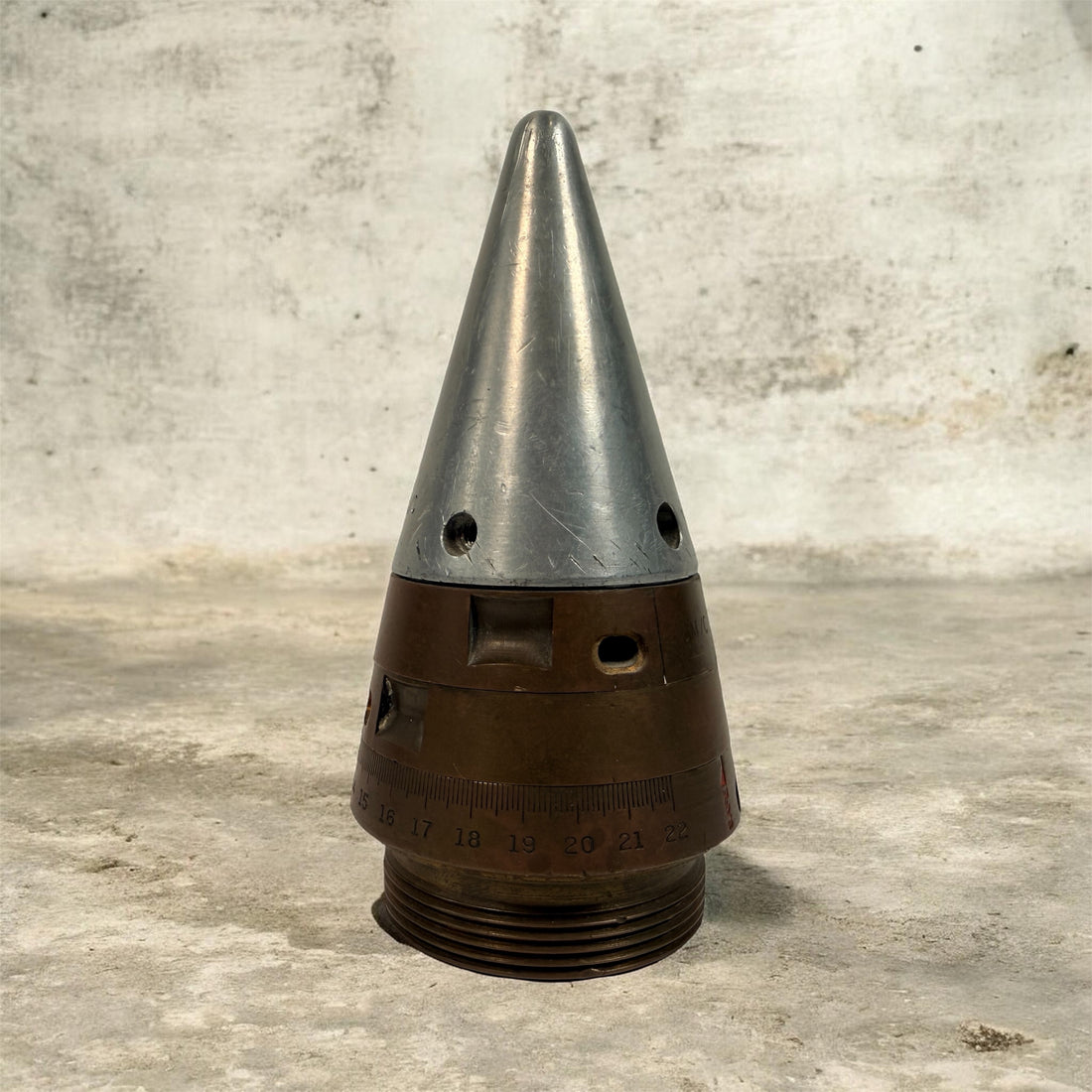 WWII British mechanical time fuze Mk IV brass and aluminum artillery nose assembly. Authentic militaria collectible with timer dial and industrial display appeal.