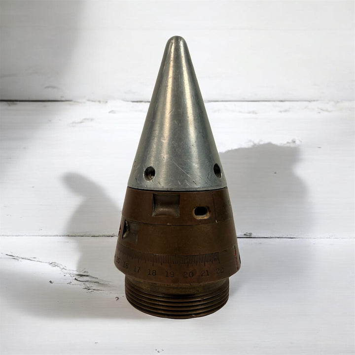 WWII British mechanical time fuze Mk IV brass and aluminum artillery nose assembly. Authentic militaria collectible with timer dial and industrial display appeal.