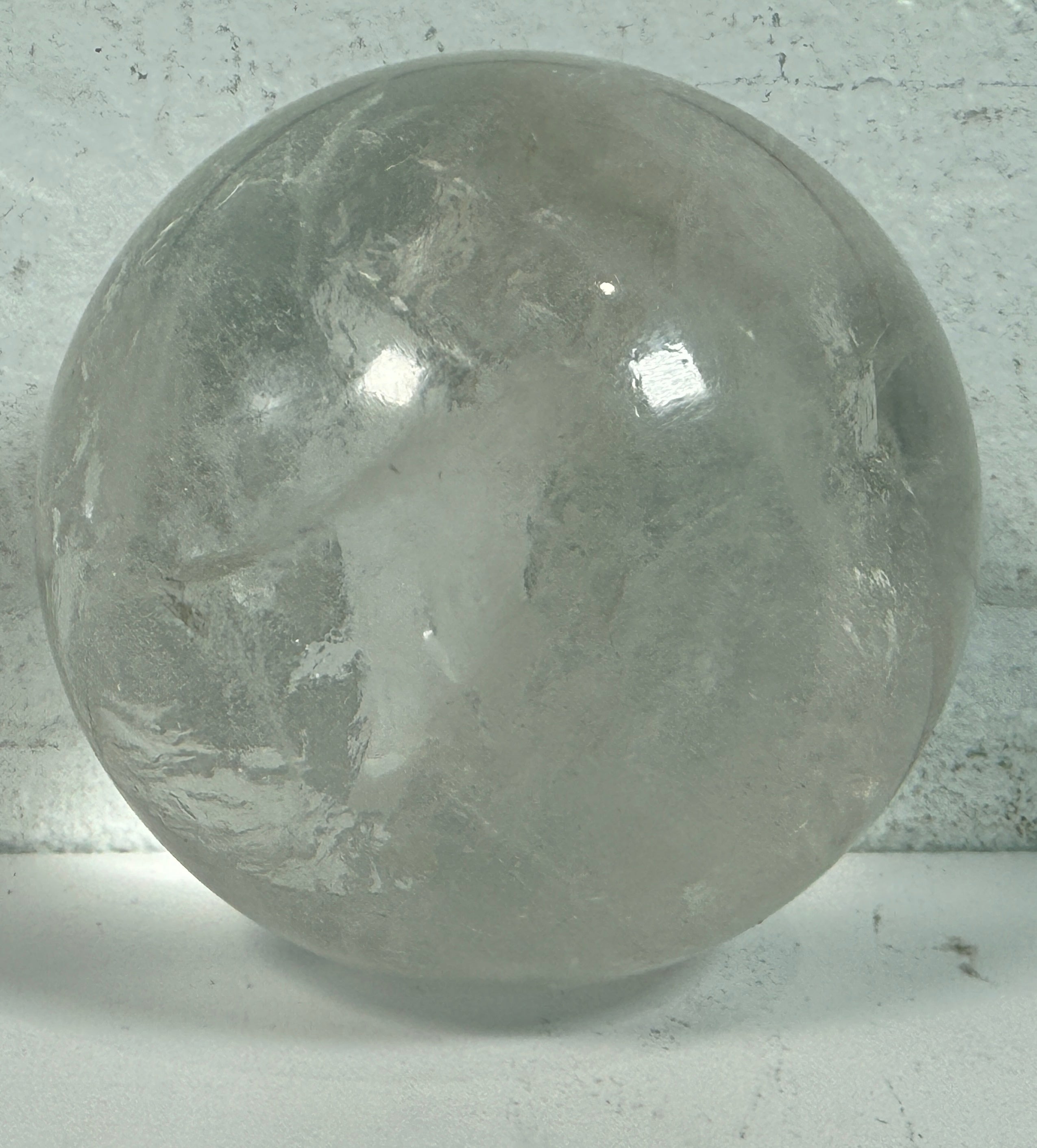 Natural clear quartz crystal sphere 70mm polished orb with beautiful internal veils and inclusions. Decorative display piece for collectors or décor.