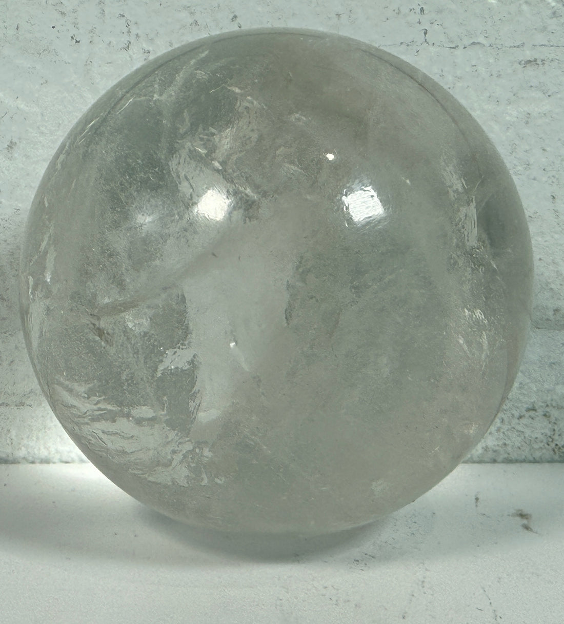 Natural clear quartz crystal sphere 70mm polished orb with beautiful internal veils and inclusions. Decorative display piece for collectors or décor.