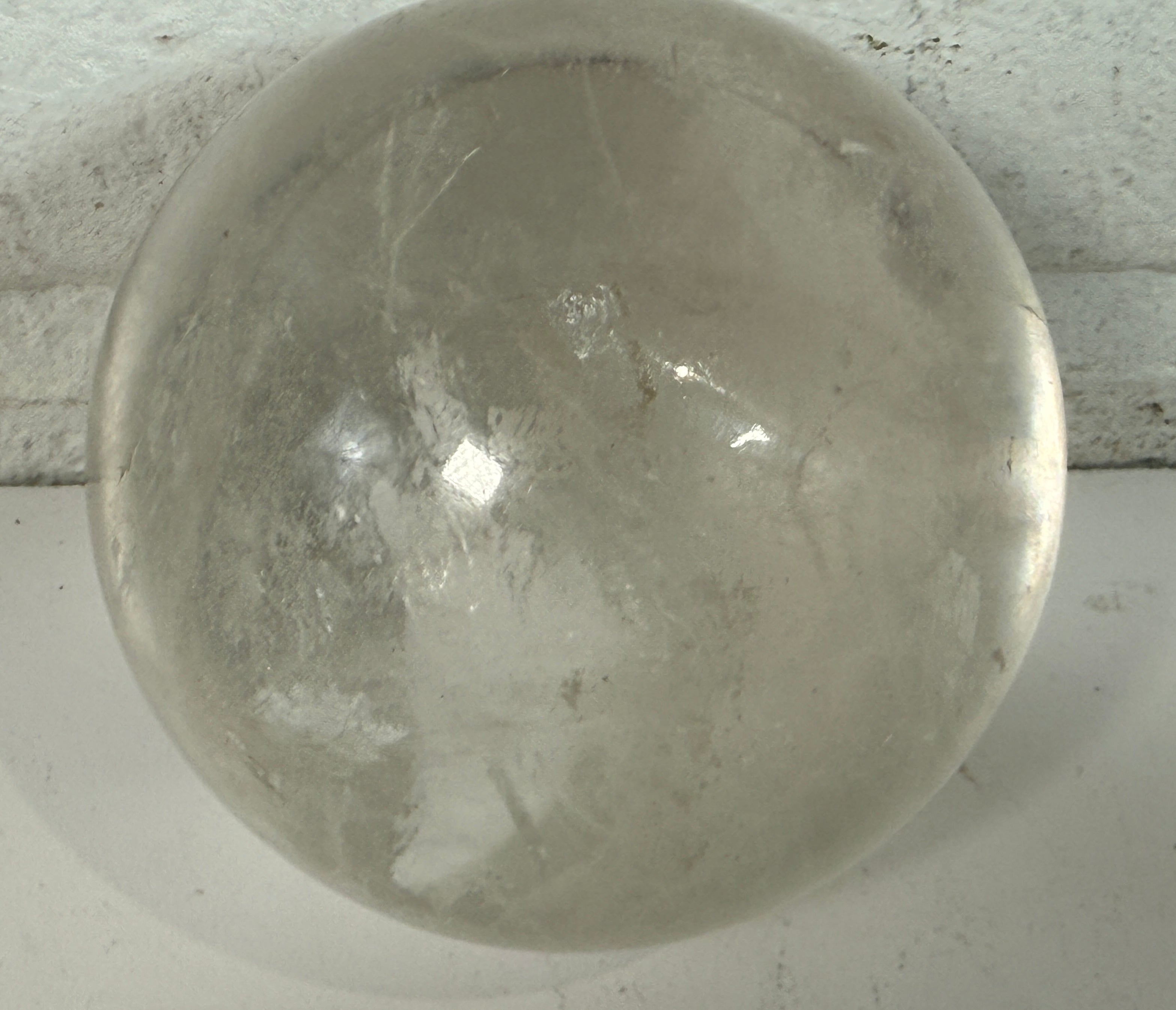 Natural clear quartz crystal sphere 70mm polished orb with beautiful internal veils and inclusions. Decorative display piece for collectors or décor.