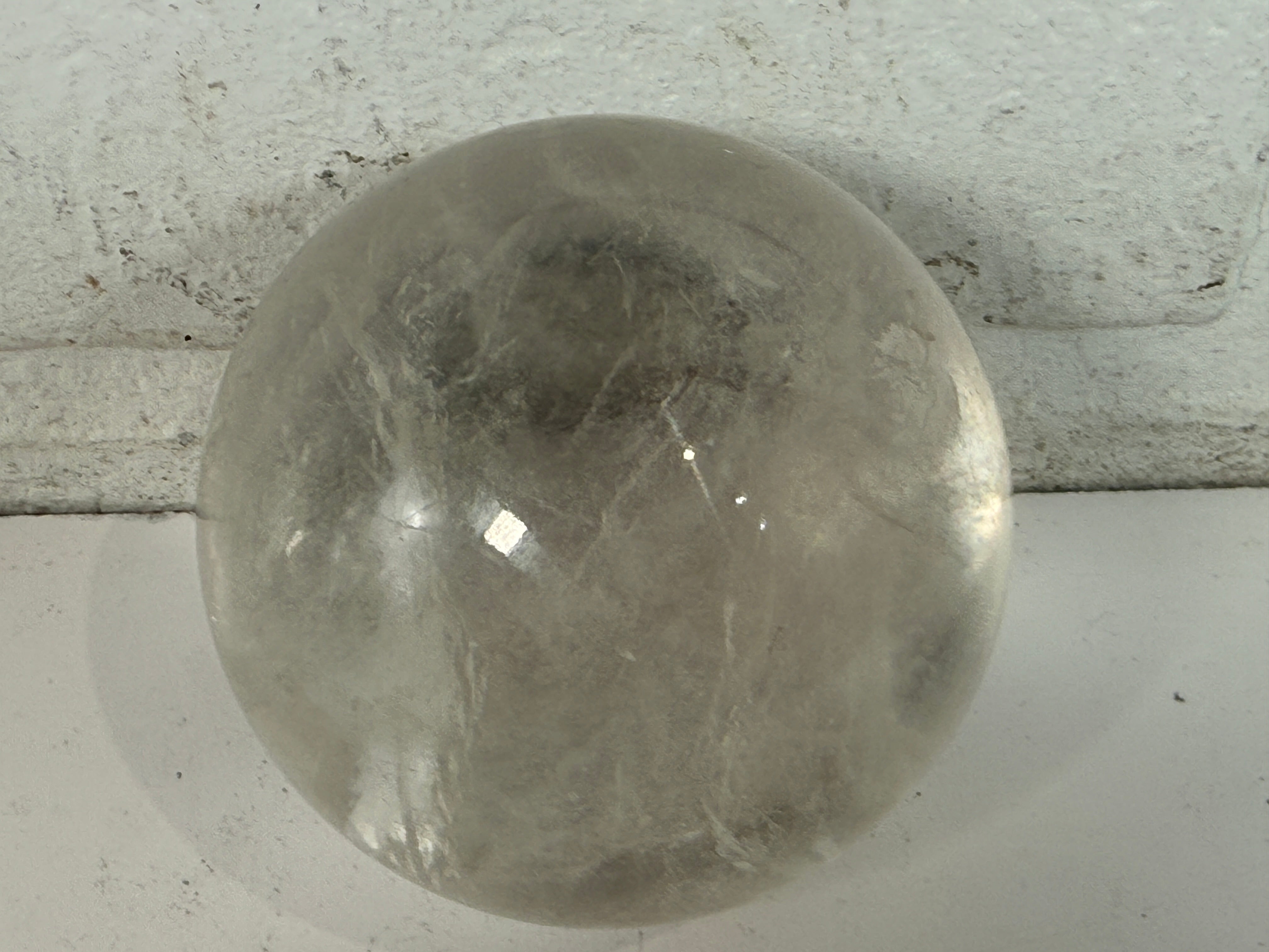 Natural clear quartz crystal sphere 70mm polished orb with beautiful internal veils and inclusions. Decorative display piece for collectors or décor.