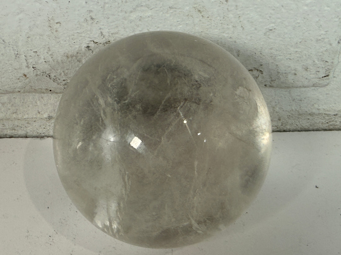 Natural clear quartz crystal sphere 70mm polished orb with beautiful internal veils and inclusions. Decorative display piece for collectors or décor.