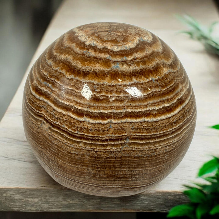 Vintage 4 inch banded onyx calcite sphere with rich honey and cream natural striping. Heavy polished stone décor piece for shelf, desk, or tabletop display.