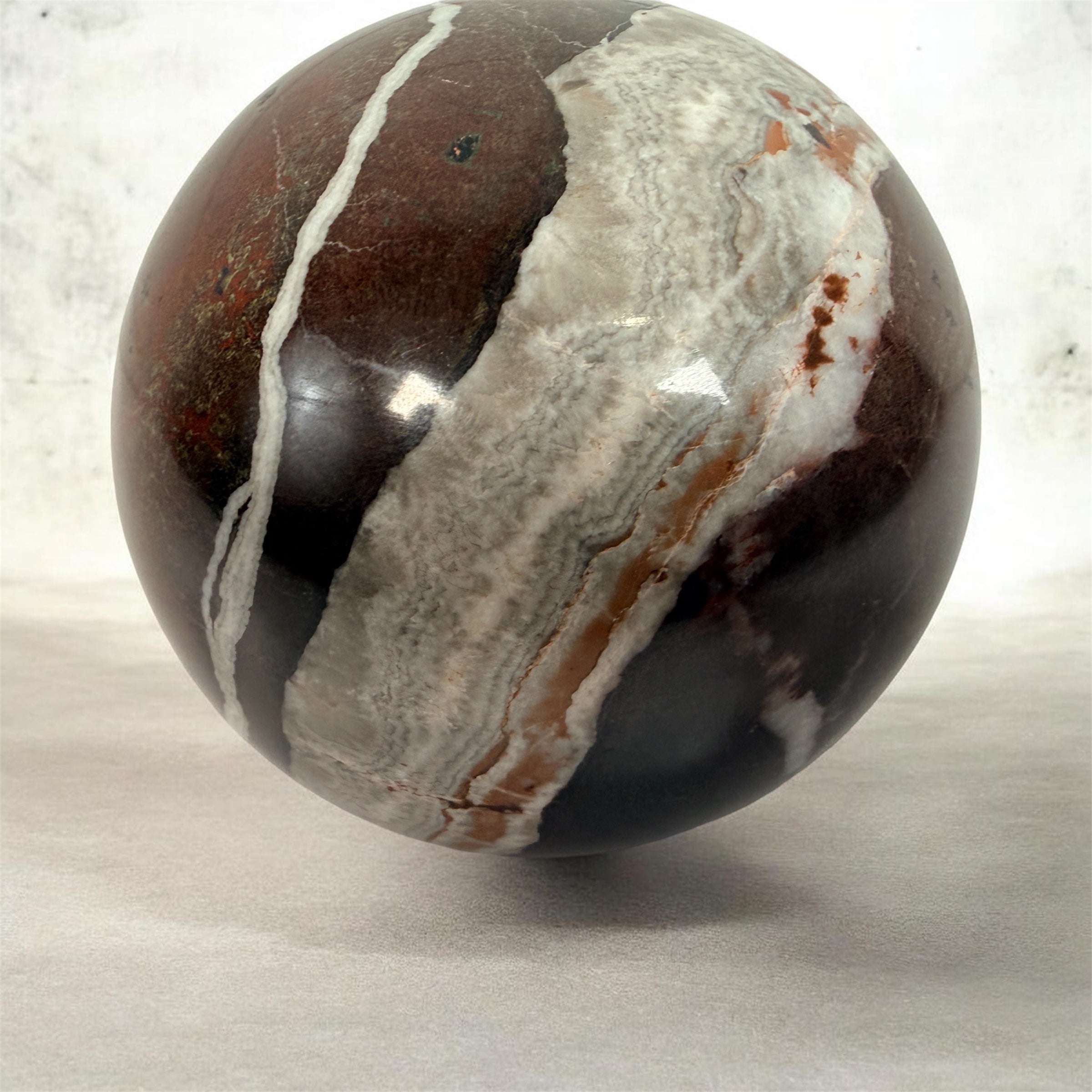 Large 4 inch Zebra Jasper sphere with rich red and white banding. Heavy polished natural stone orb, ideal for décor, gifting, or collectors.