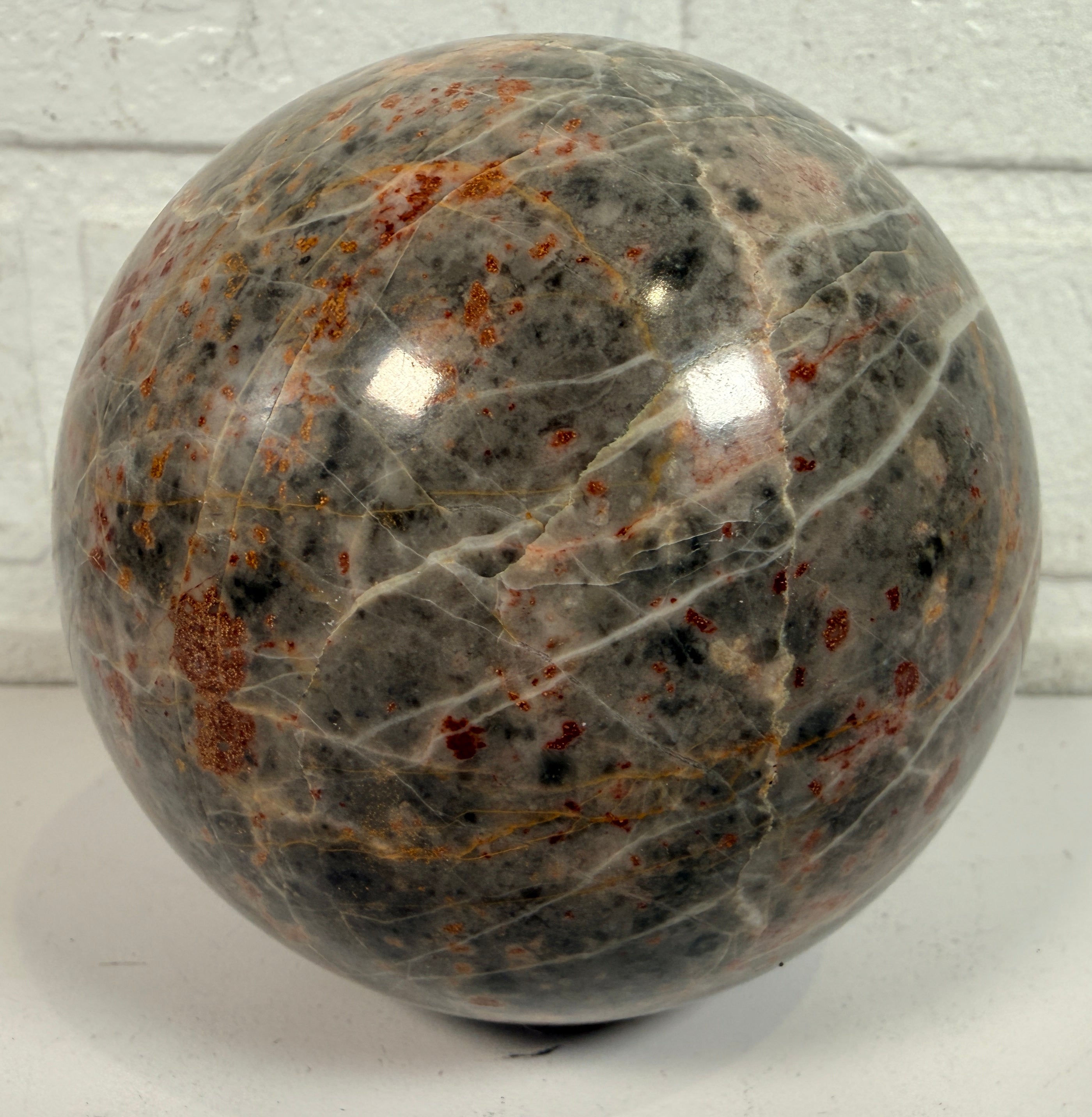 Grande sphère en jaspe gris poli, inclusions de fer rouge, 10 cm