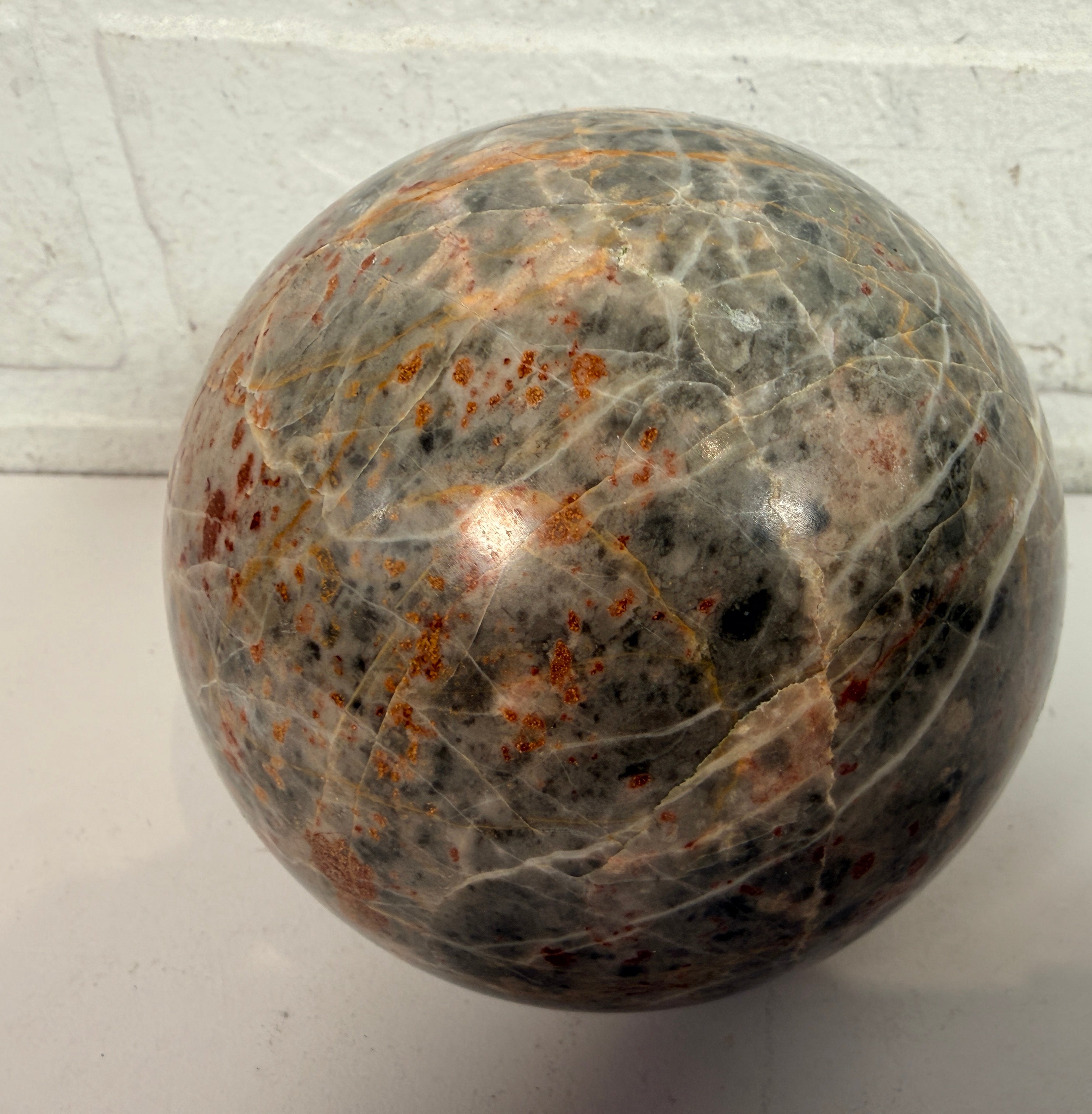 Grande sphère en jaspe gris poli, inclusions de fer rouge, 10 cm