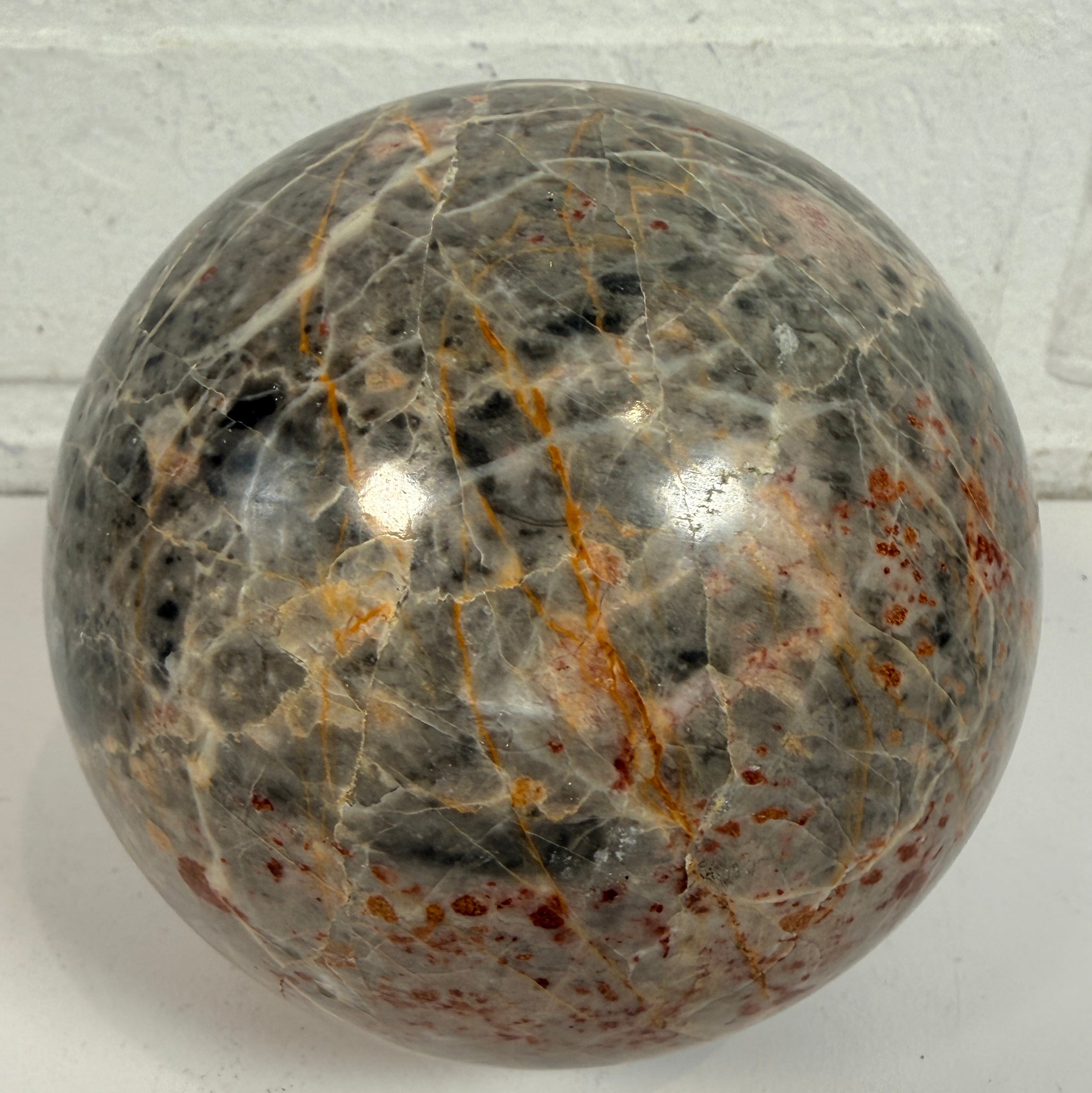 Grande sphère en jaspe gris poli, inclusions de fer rouge, 10 cm