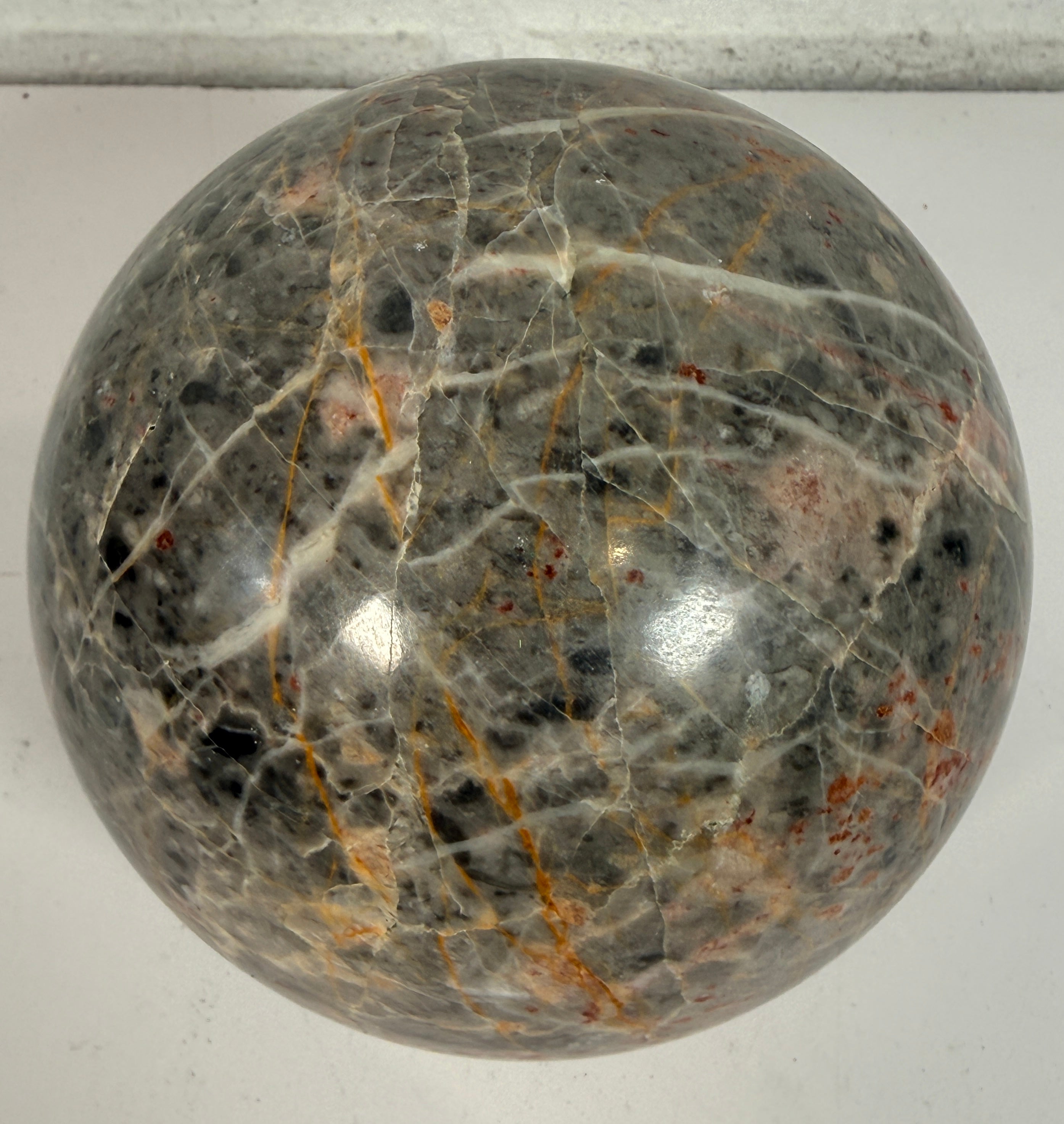 Grande sphère en jaspe gris poli, inclusions de fer rouge, 10 cm