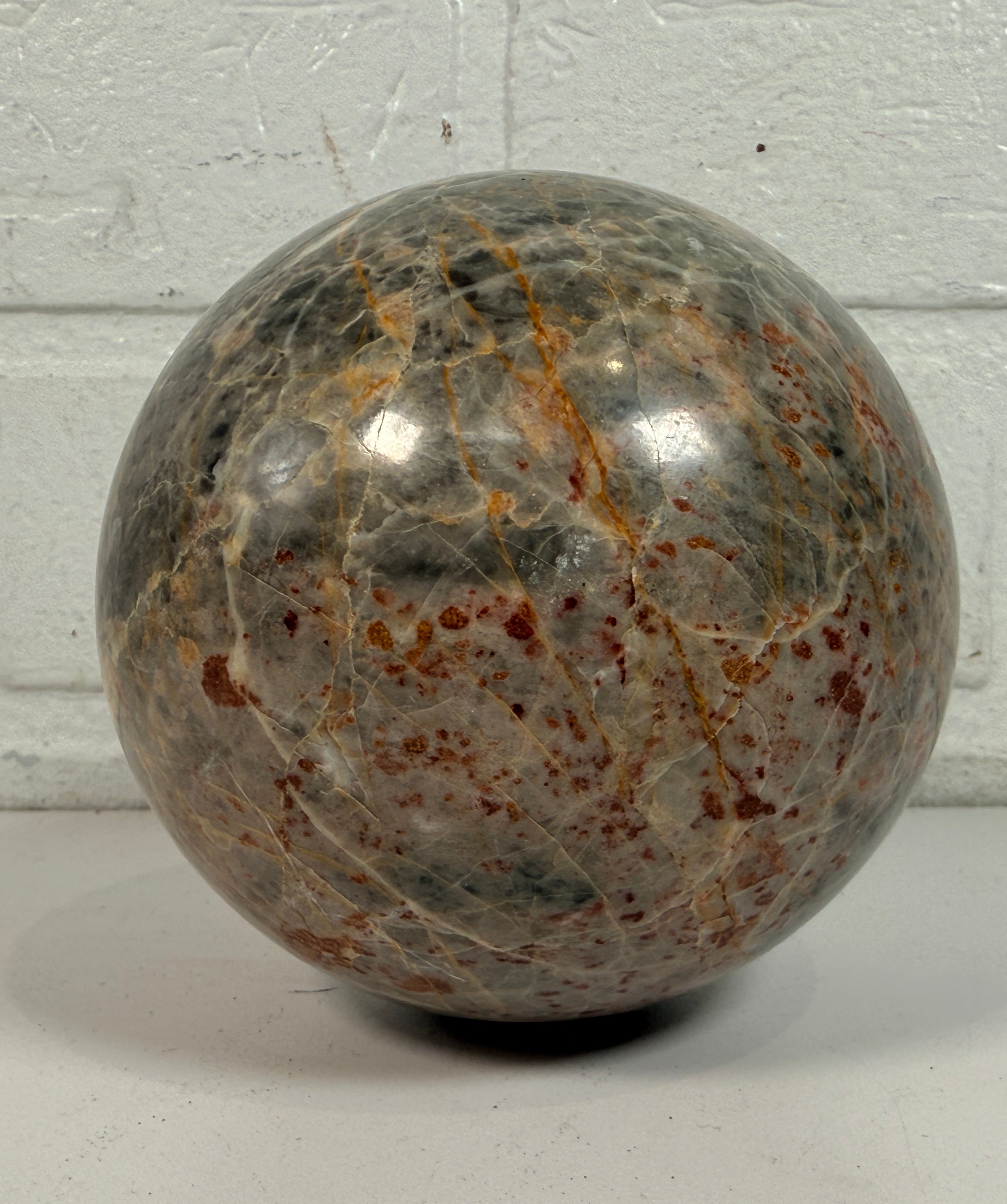 Grande sphère en jaspe gris poli, inclusions de fer rouge, 10 cm