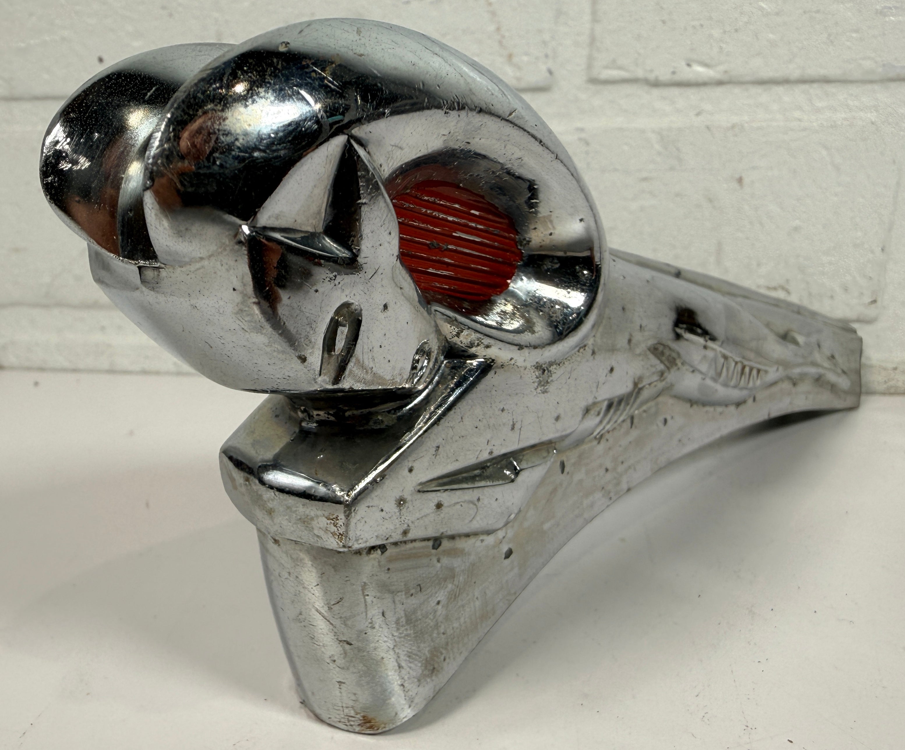 Vintage Dodge Ram hood ornament with red eyes, chrome mascot from the 1950s. Rare automobilia collectible for restoration, garage décor, or display
