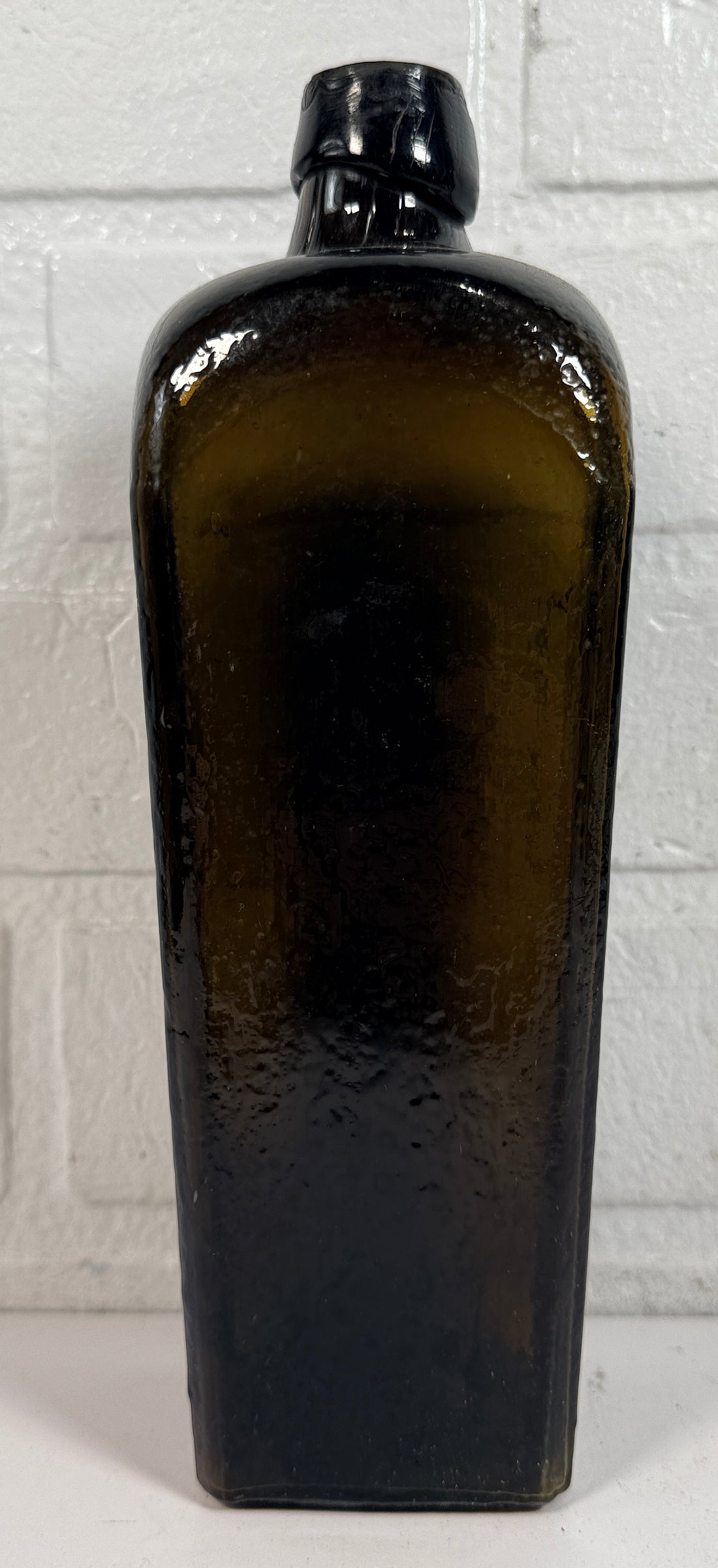 Collectible olive glass Case Gin bottle in classic Dutch jenever style. Square tapered vintage bottle perfect for bar decor, bottle collectors, and display.