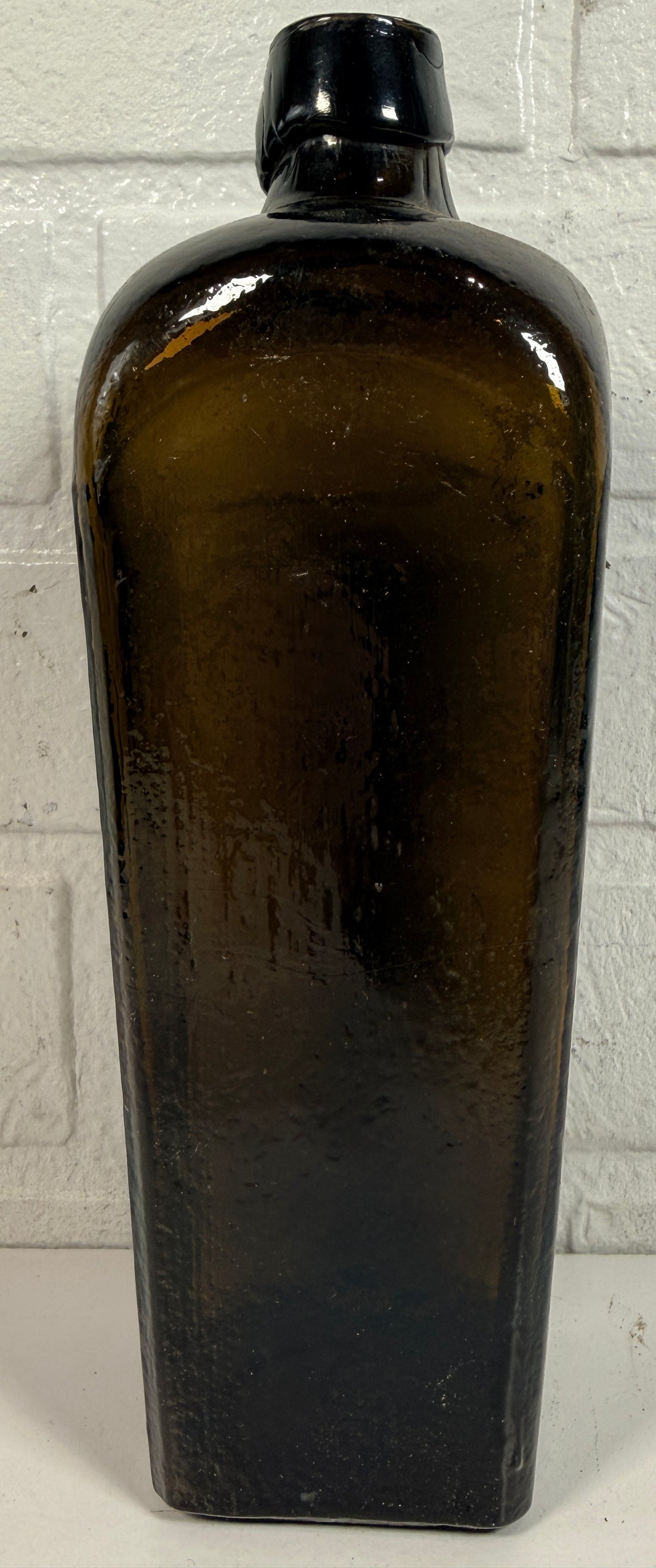 Collectible olive glass Case Gin bottle in classic Dutch jenever style. Square tapered vintage bottle perfect for bar decor, bottle collectors, and display.