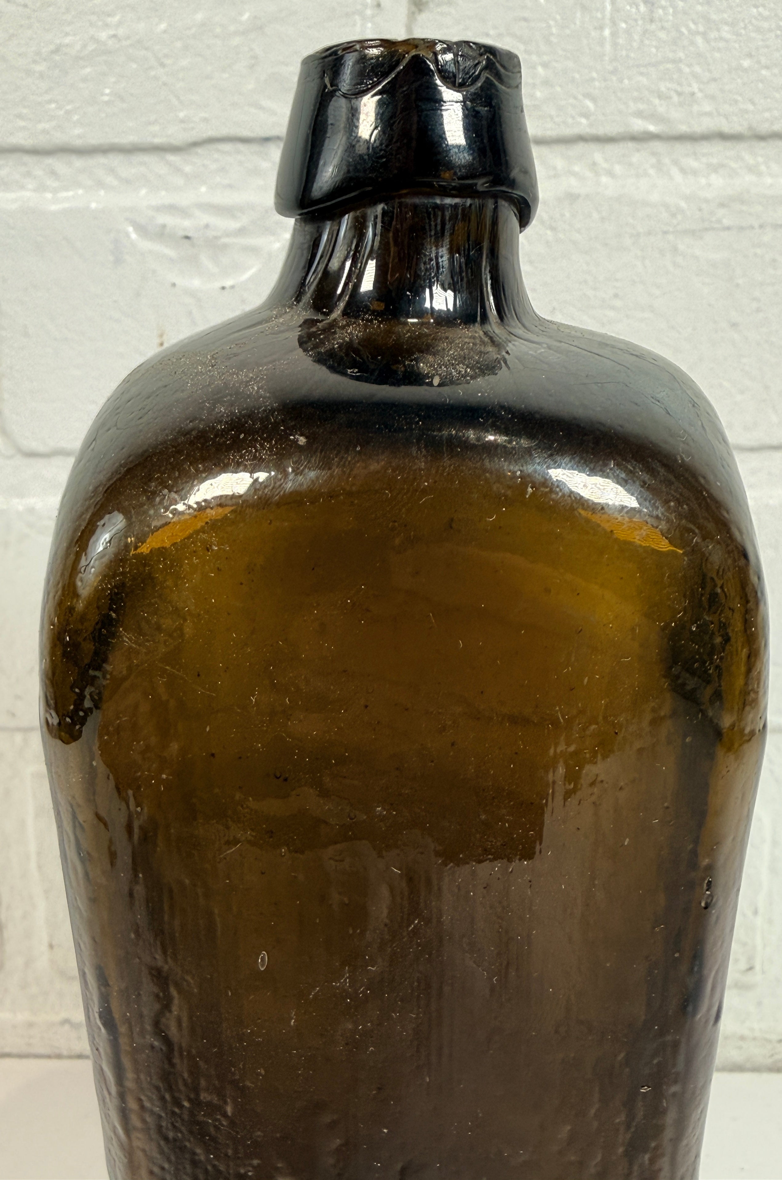 Collectible olive glass Case Gin bottle in classic Dutch jenever style. Square tapered vintage bottle perfect for bar decor, bottle collectors, and display.