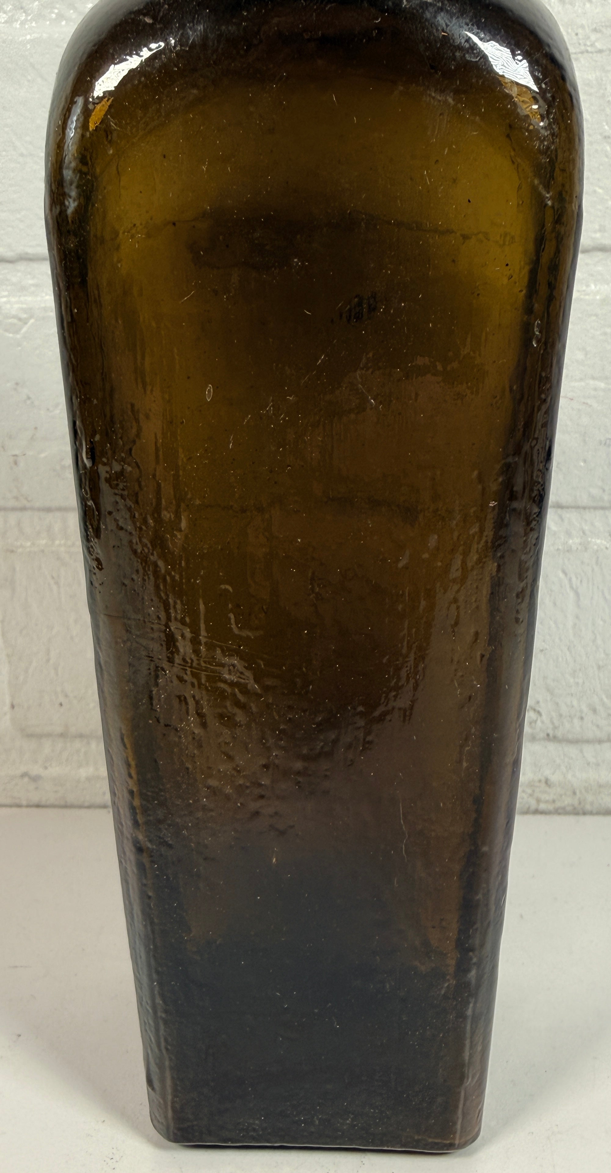 Bouteille de gin de collection en verre olive, style genièvre hollandais, carrée et effilée.
