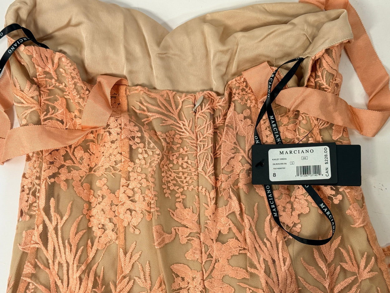 Marciano Kailey Dress size 8 in coral pink embroidered lace. Elegant formal gown with tags, fitted silhouette and sheer floral overlay.
