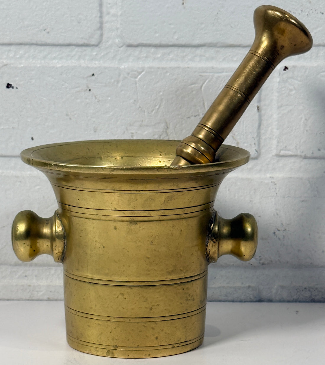 Vintage brass apothecary mortar and pestle, heavy cast with flared rim and rich patina. Classic pharmacy décor piece, functional and collectible.