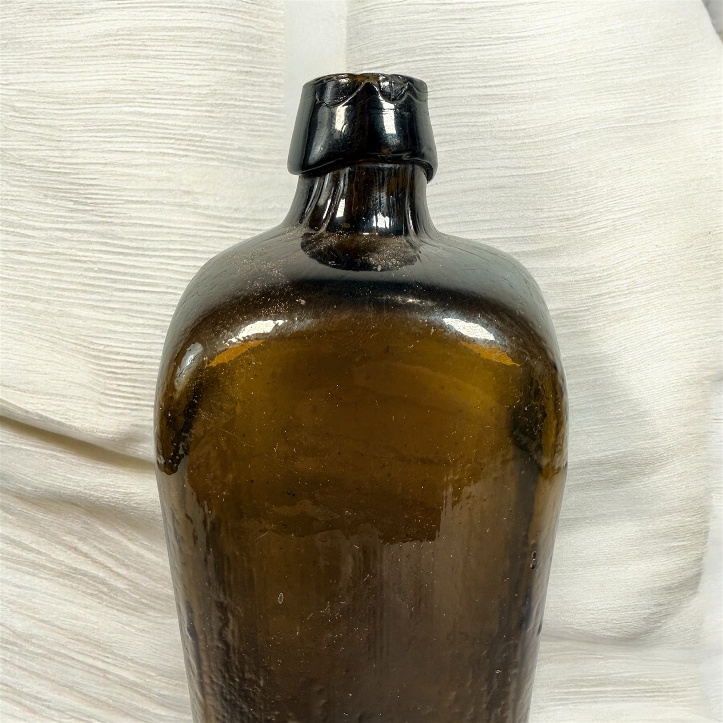 Collectible olive glass Case Gin bottle in classic Dutch jenever style. Square tapered vintage bottle perfect for bar decor, bottle collectors, and display.