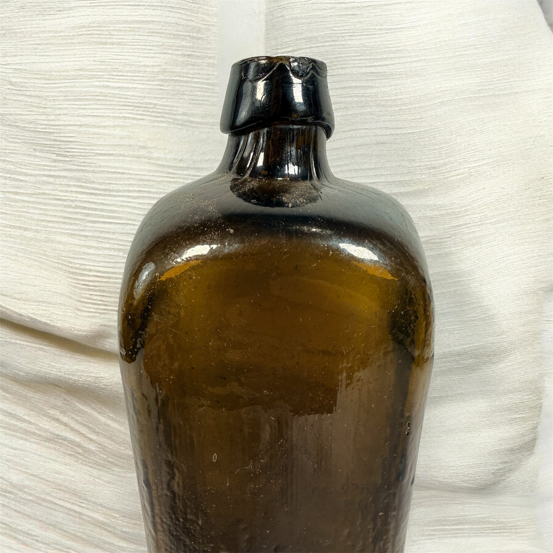 Collectible olive glass Case Gin bottle in classic Dutch jenever style. Square tapered vintage bottle perfect for bar decor, bottle collectors, and display.