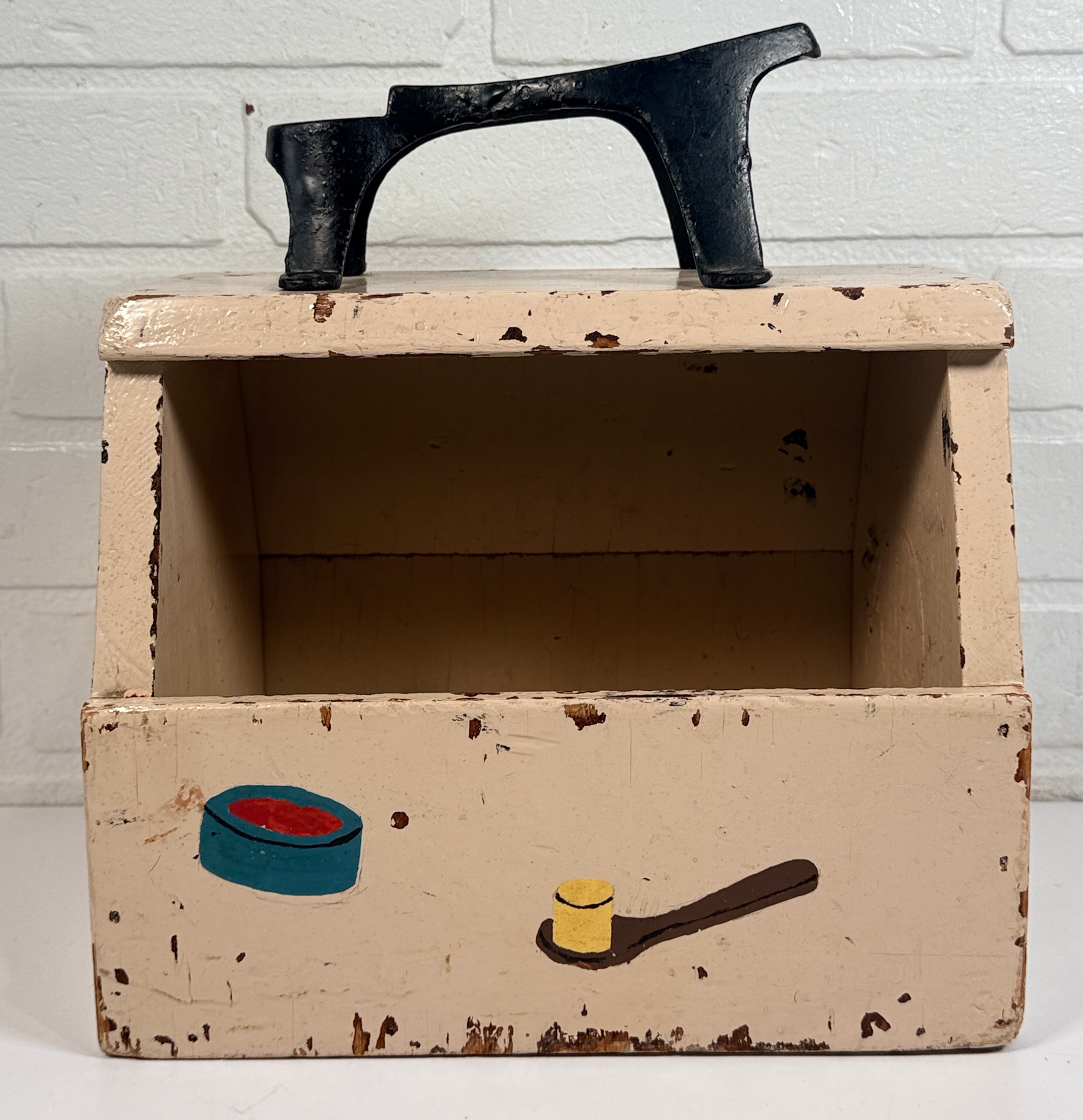 Vintage folk art shoe shine box with cast iron footrest handle. Rustic wooden cobbler caddy with hand-painted details, perfect for decor or storage.