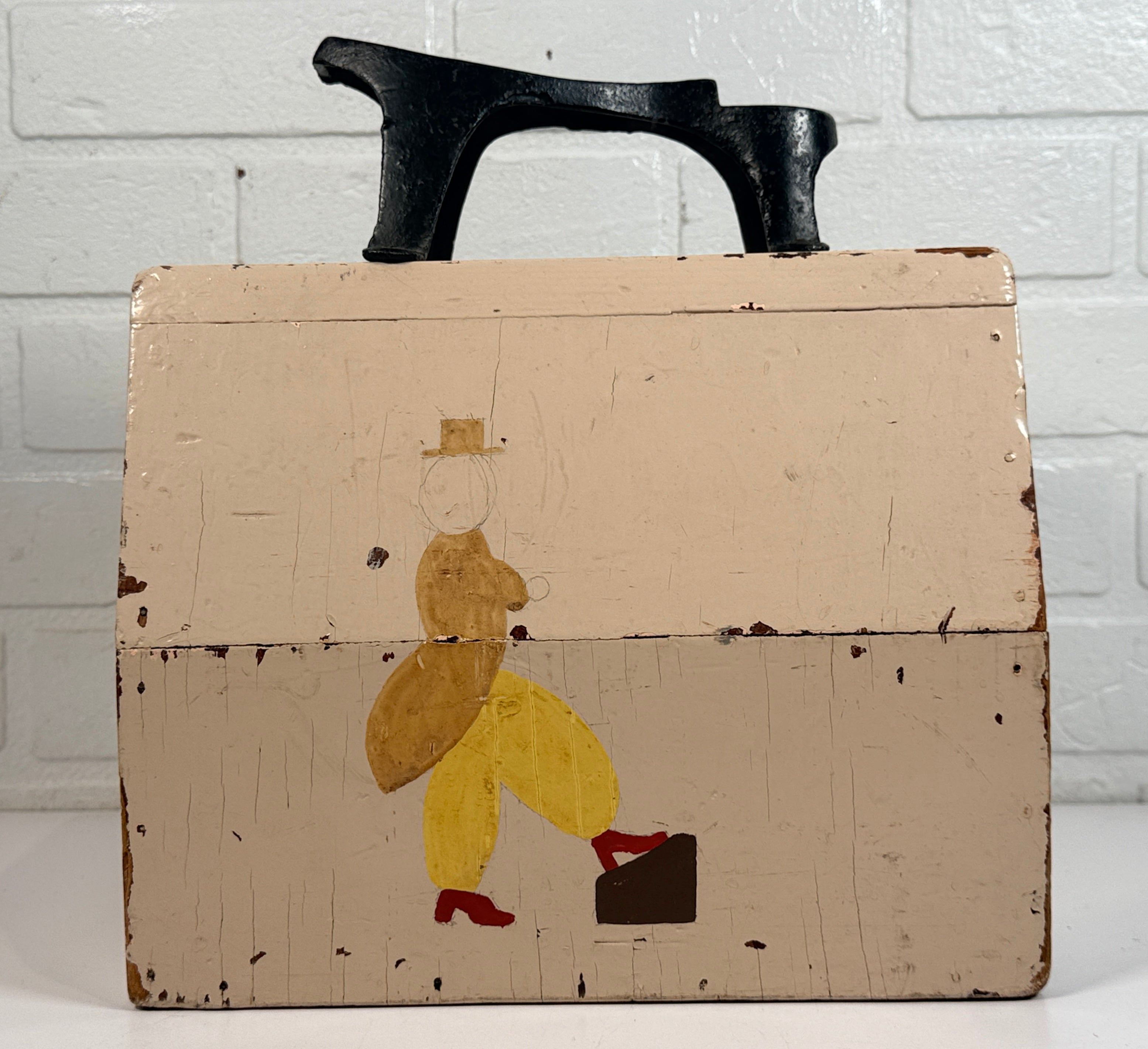 Vintage folk art shoe shine box with cast iron footrest handle. Rustic wooden cobbler caddy with hand-painted details, perfect for decor or storage.