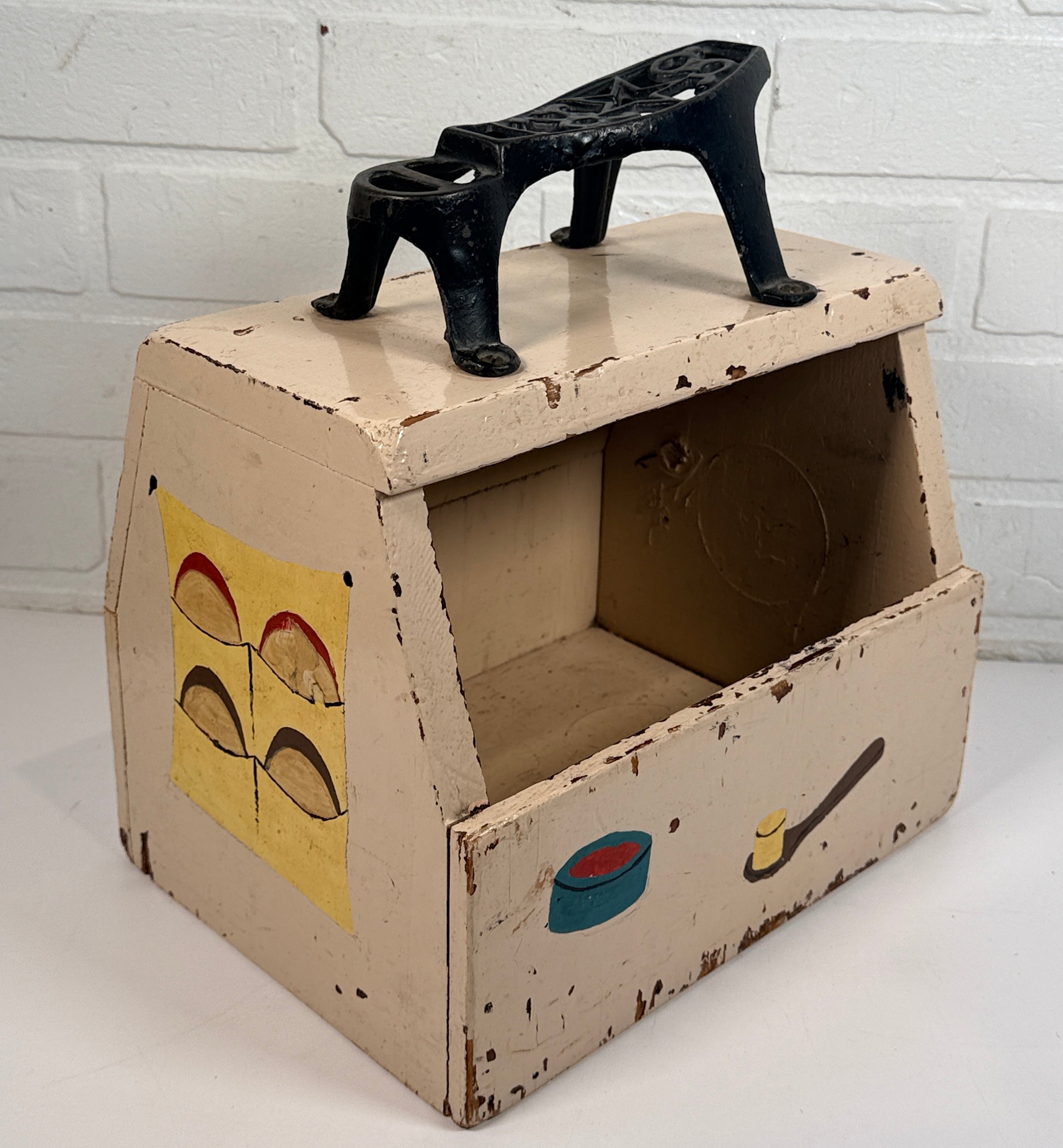 Vintage folk art shoe shine box with cast iron footrest handle. Rustic wooden cobbler caddy with hand-painted details, perfect for decor or storage.