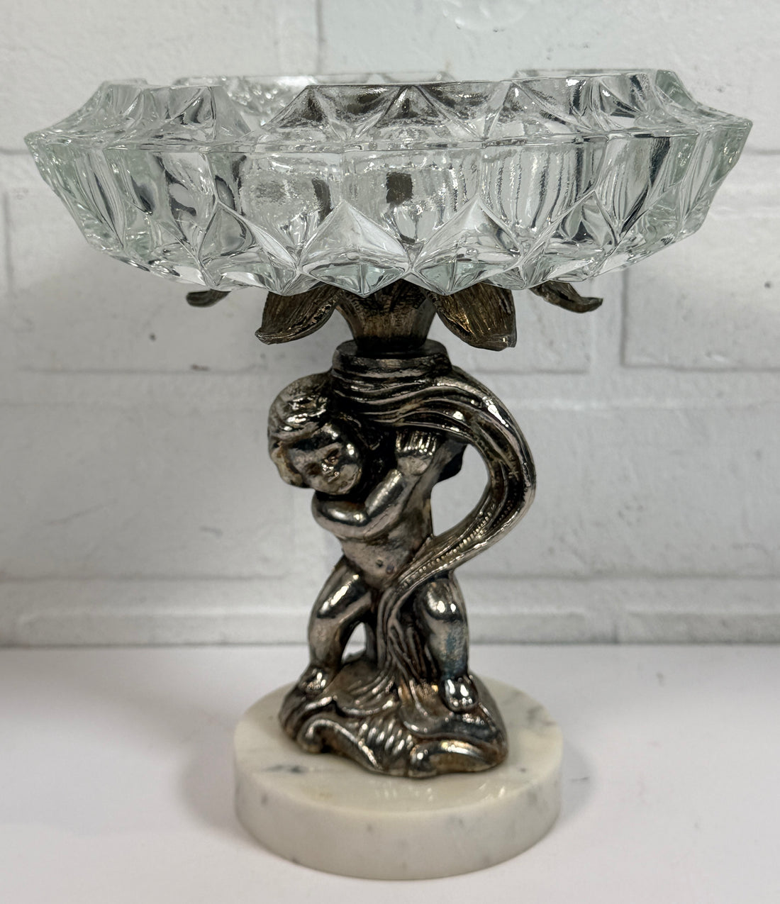 Vintage Hollywood Regency cherub pedestal dish with glass bowl and marble base. Elegant mid-century décor perfect for trinkets, candy, or display.