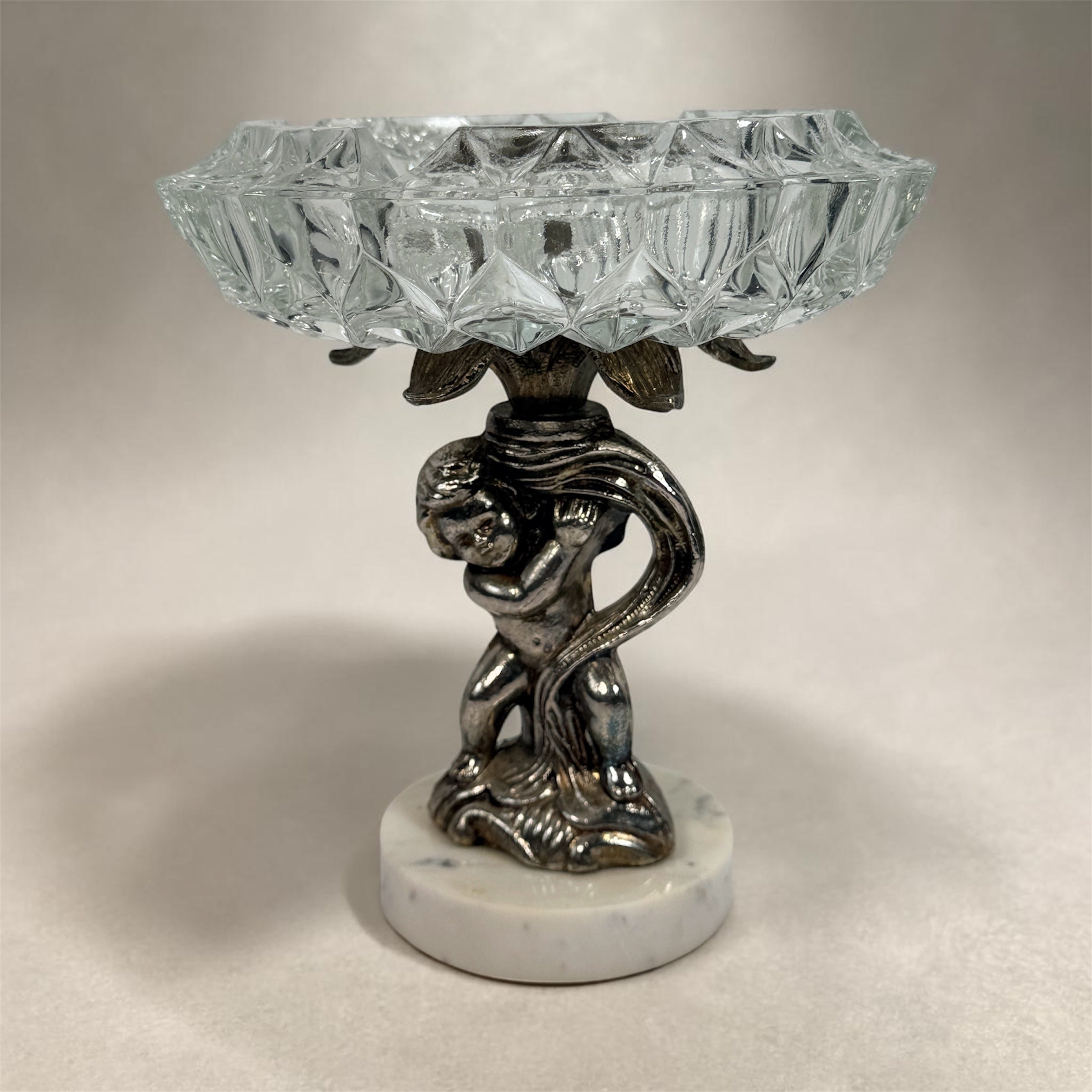 Vintage Hollywood Regency cherub pedestal dish with glass bowl and marble base. Elegant mid-century décor perfect for trinkets, candy, or display.