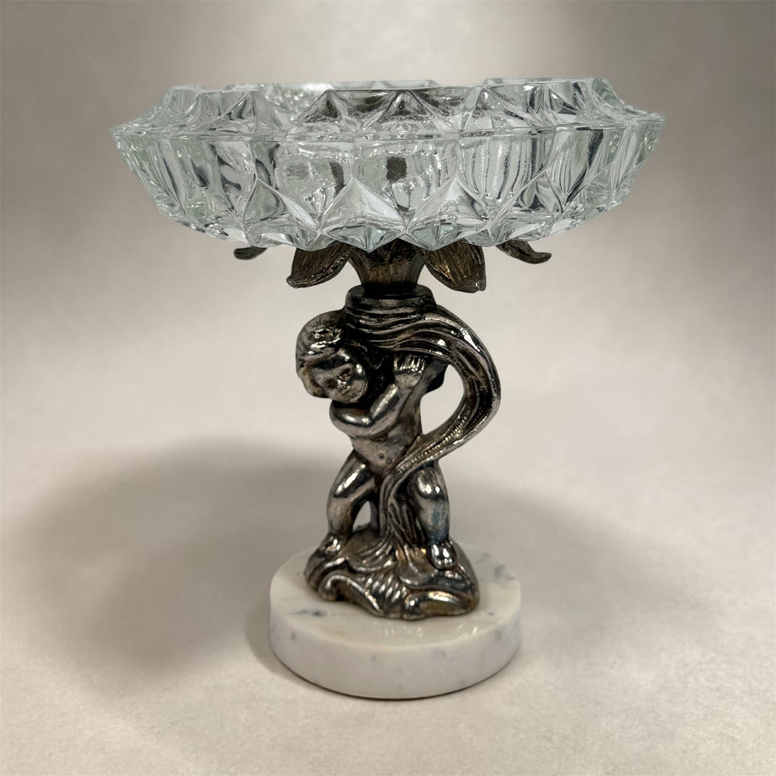 Vintage Hollywood Regency cherub pedestal dish with glass bowl and marble base. Elegant mid-century décor perfect for trinkets, candy, or display.