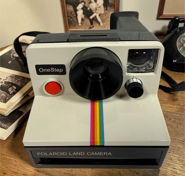 Vintage Polaroid OneStep SX-70 instant camera with rainbow stripe design. Untested and sold as-is. Great collectible retro display camera.