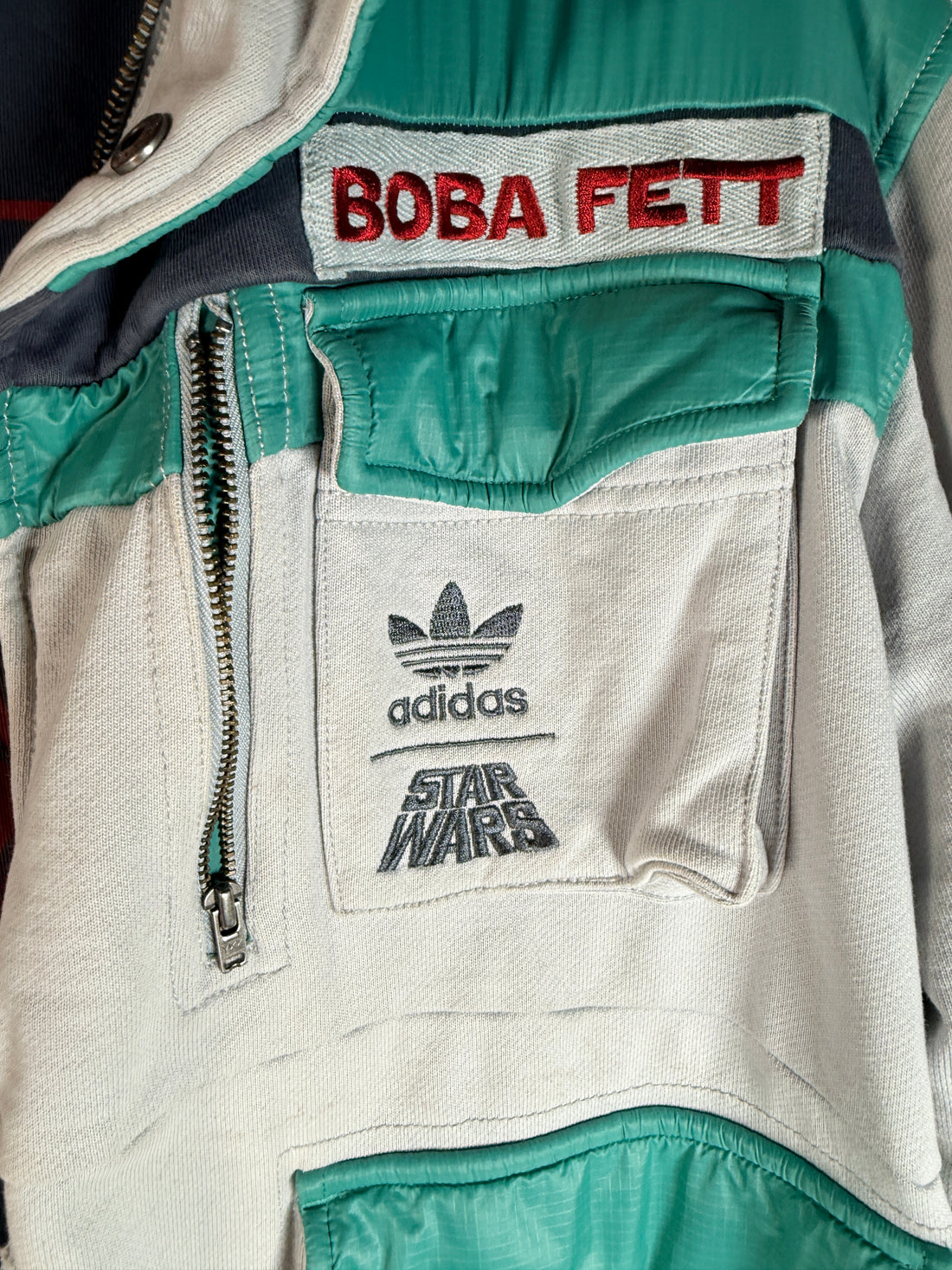 Adidas Star Wars Boba Fett jacket with tactical design and embroidered logos. Pre-owned with visible staining, priced for value and everyday wear appeal.