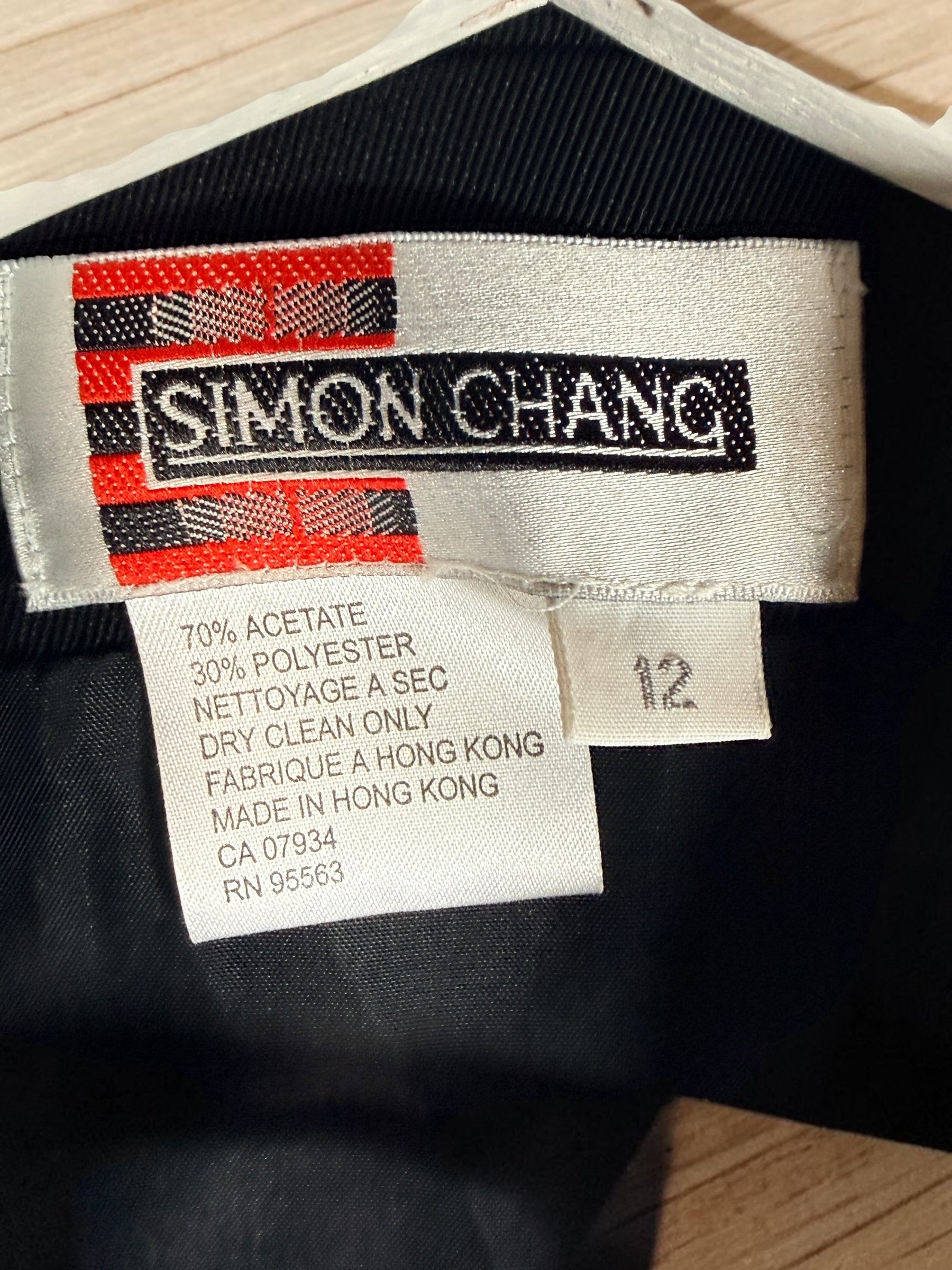 Vintage Simon Chang black blazer with zip waist detail, structured 90s silhouette, size 12. Classic tailored piece with unique design accent.