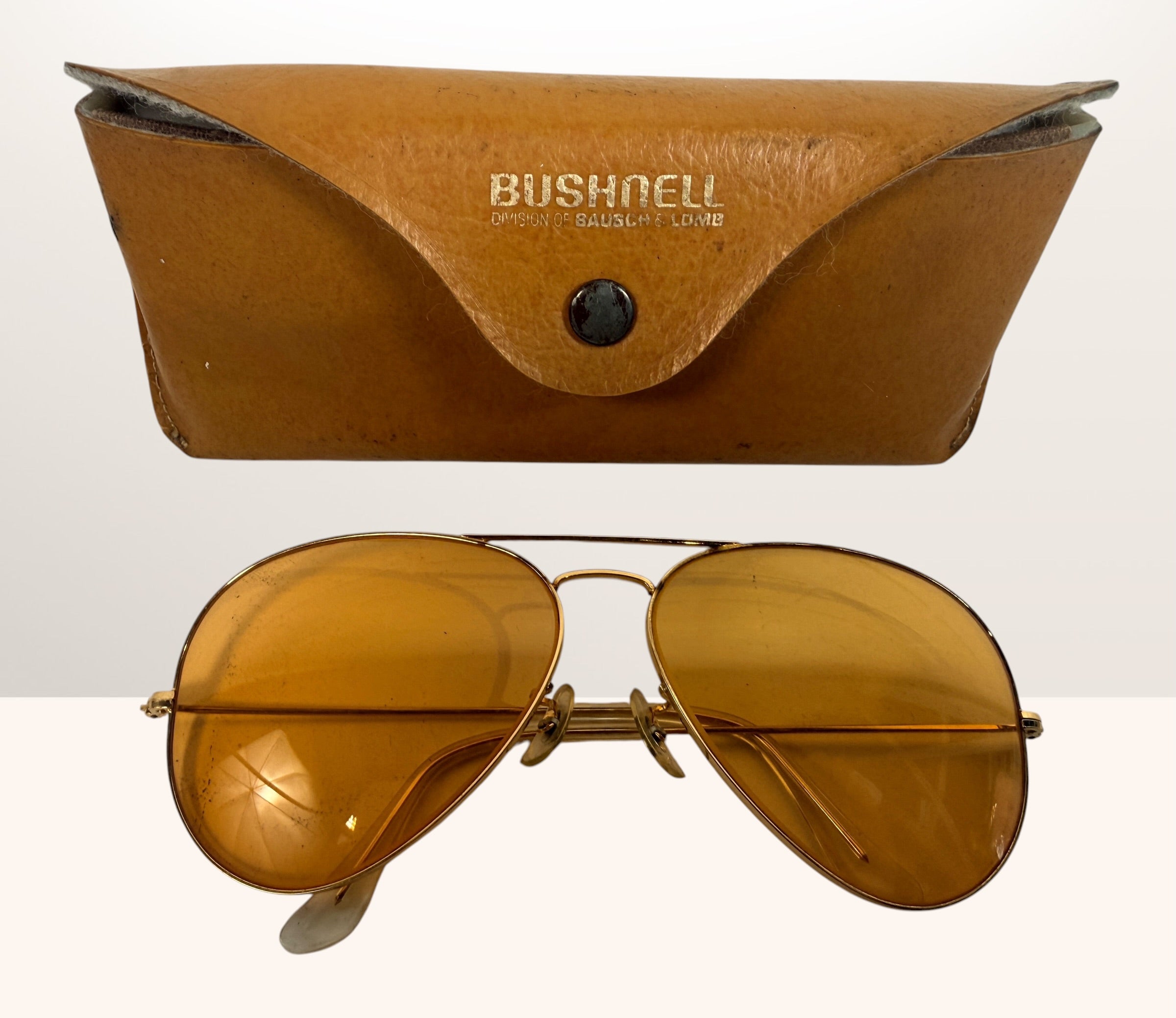Vintage Bushnell B&amp;L aviator sunglasses with amber lenses and original case, made in USA retro shooting and driving glasses from the 1970s era.