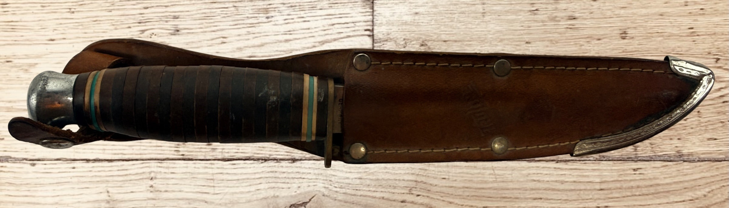 Vintage TRULINE Solingen Germany hunting knife with original leather sheath. Classic stacked leather fixed blade collectible from the mid-century era.
