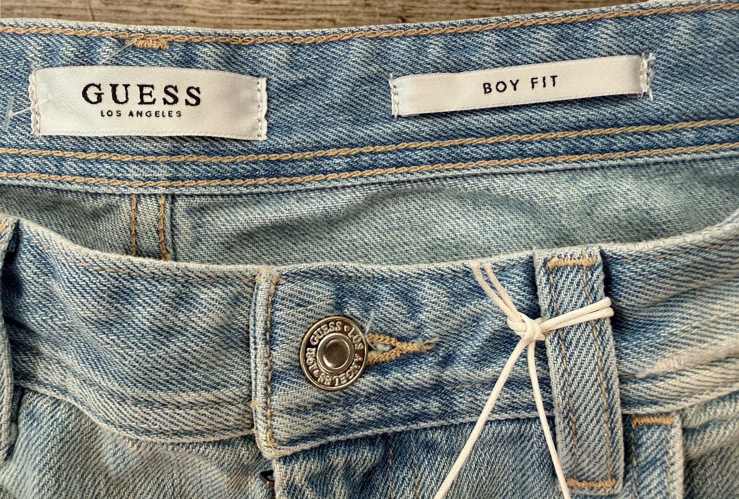 GUESS Boy Fit distressed jeans in light wash denim, size 29, new with tags. Trendy ripped boyfriend-fit jeans with modern Y2K streetwear style.